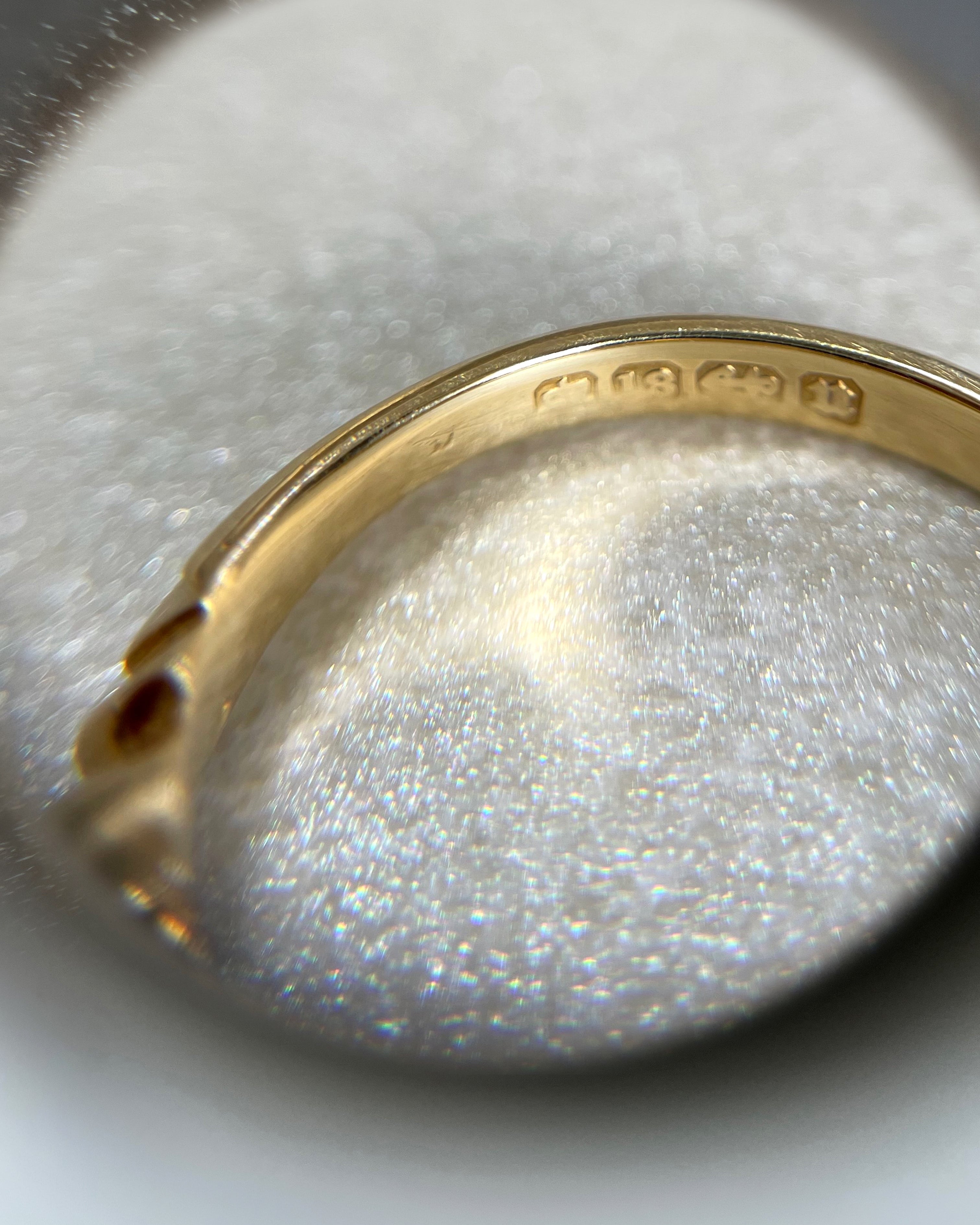 Close-up of Victorian 18kt gold diamond ring through jeweller’s loupe showing English hallmarks – Auric Vintage