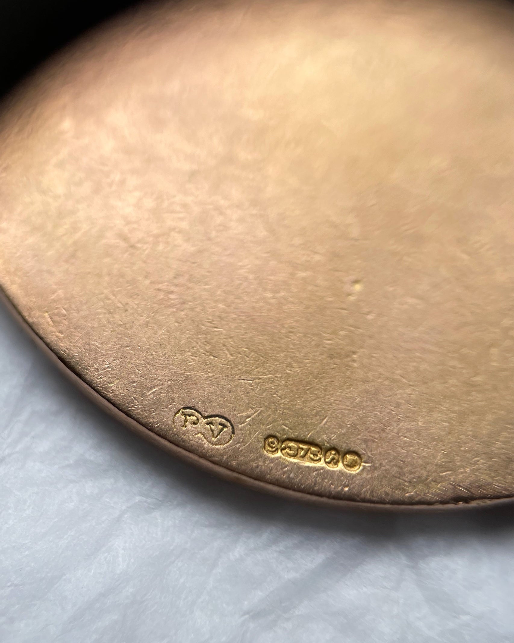 Close-up of vintage 9kt gold St. Christopher medal showing London hallmarks and maker’s mark – Auric Vintage