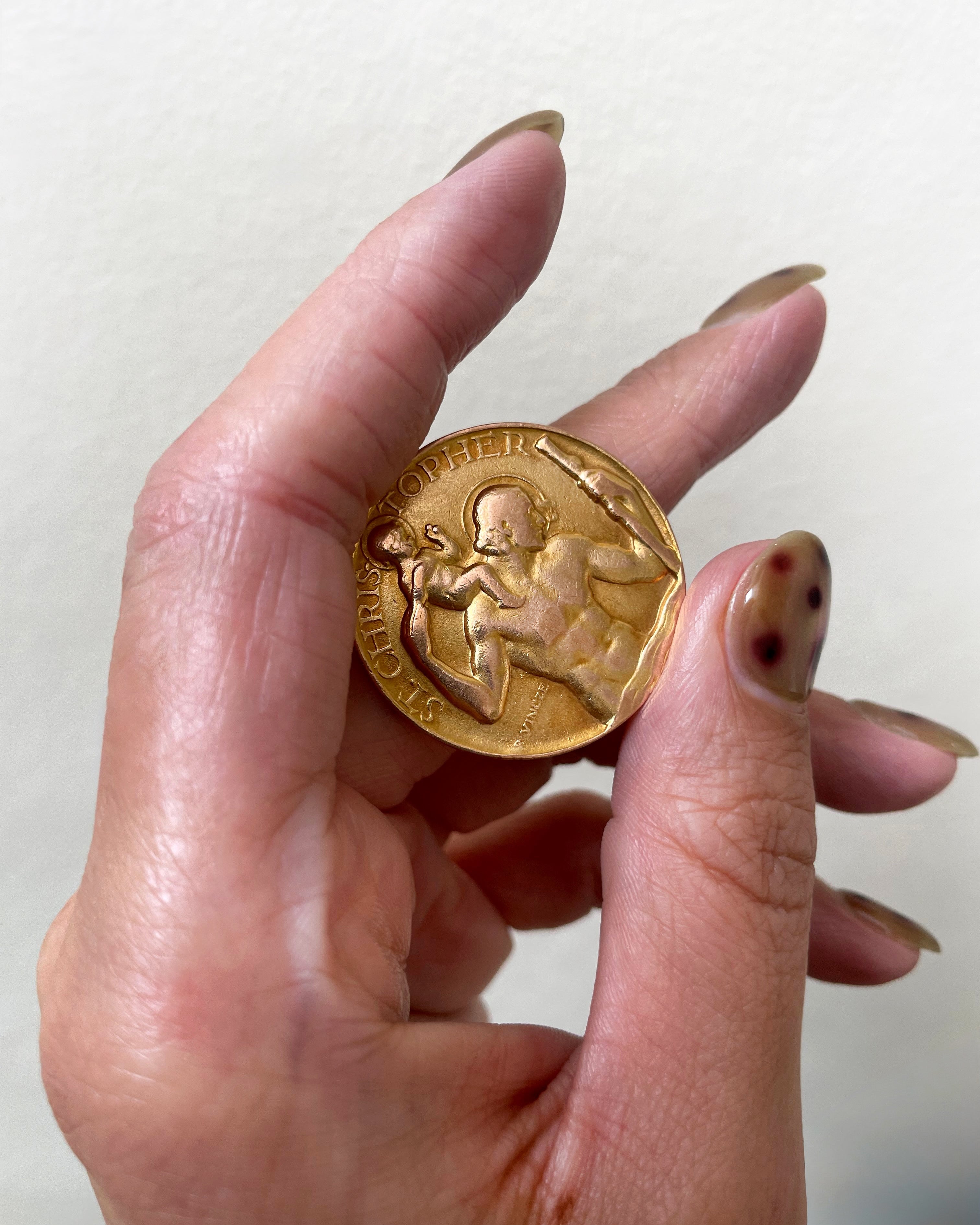 Vintage St. Christopher medal in 9kt gold by Paul Vincze held in hand showing scale and figural detail – Auric Vintage