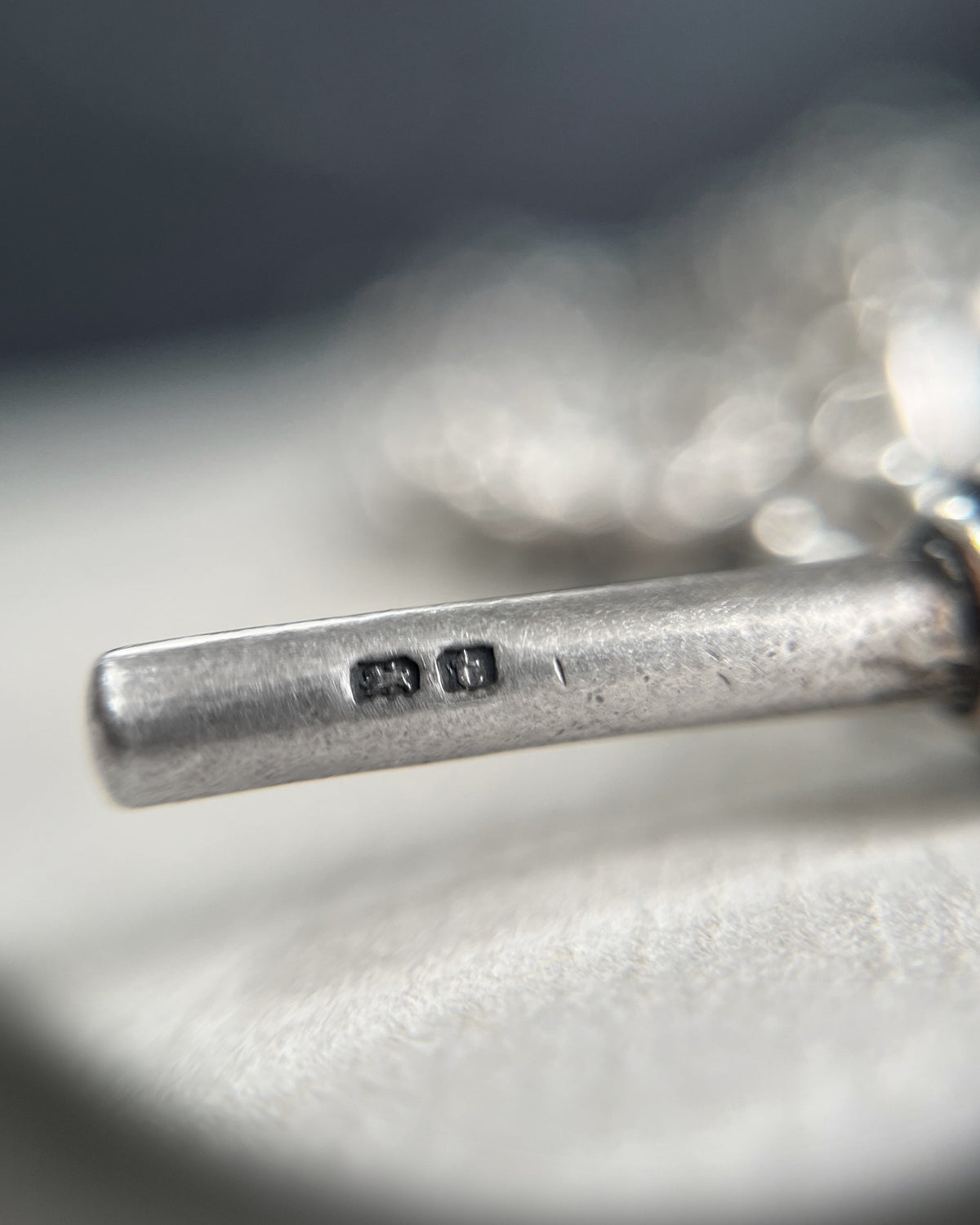 Magnified close-up of the lion passant Sterling silver hallmark and maker's mark on the T-bar, showing the Birmingham 1918 assay mark.