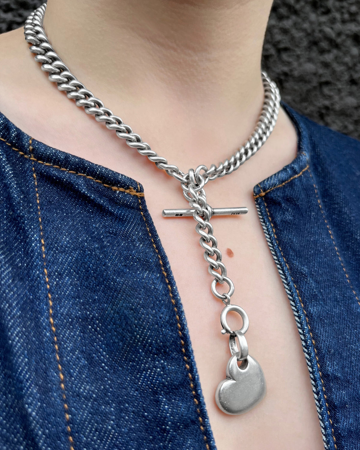 Antique Sterling silver watch chain worn around the neck with a heart pendant, T-bar and additional curb link chain, styled with a denim top.