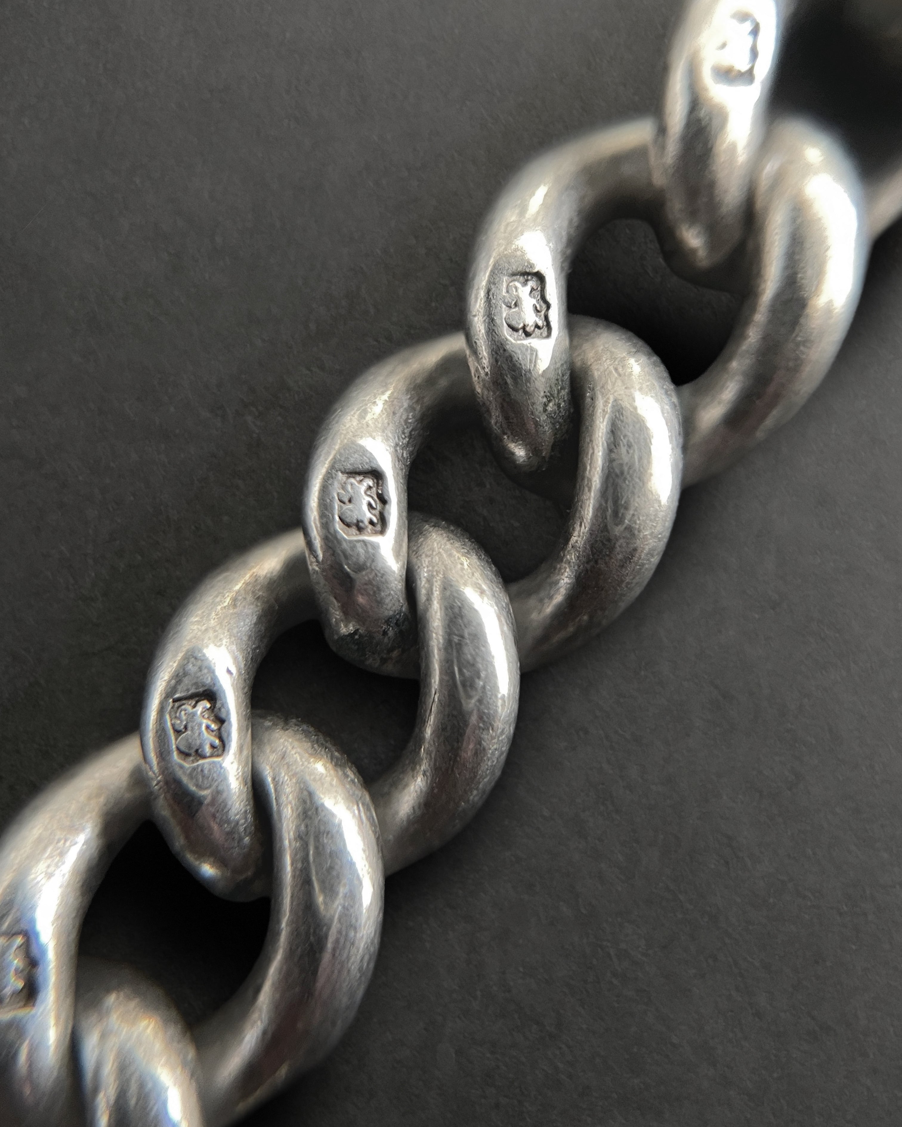 Close-up of Edwardian sterling silver chain showing lion passant marks on links – Auric Vintage