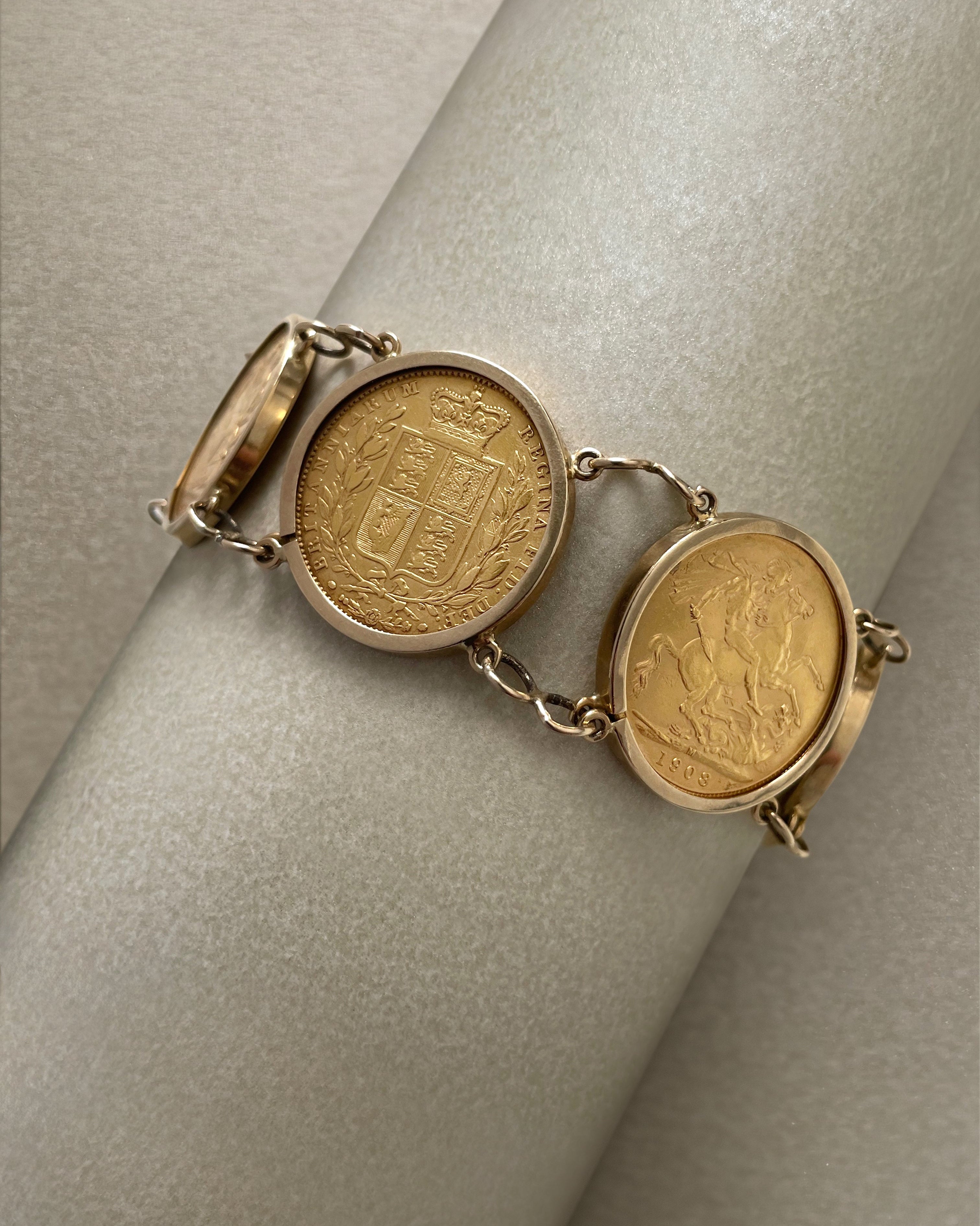 Antique six full sovereign coin bracelet in gold displayed on bracelet holder showing Victorian and Edwardian coins – Auric Vintage