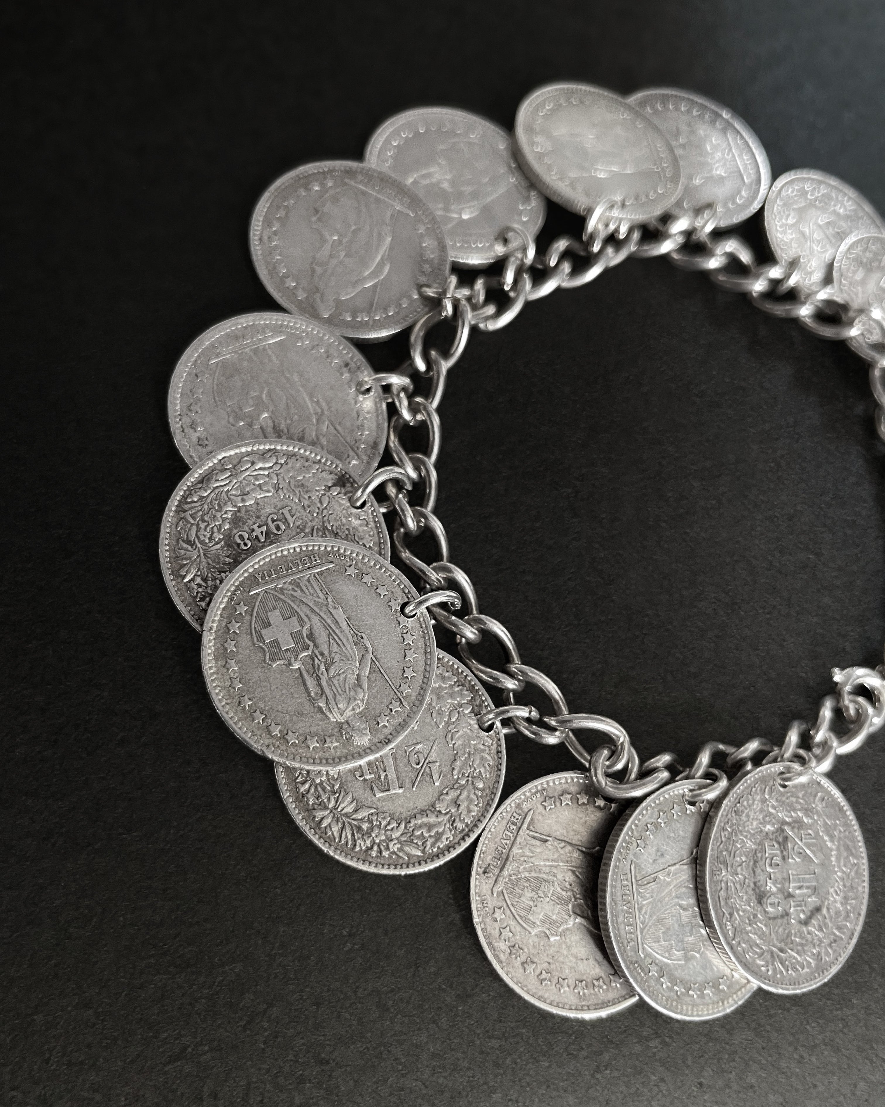 Close-up of vintage silver Swiss half-franc coin bracelet showing coin charms and link detail – Auric Vintage