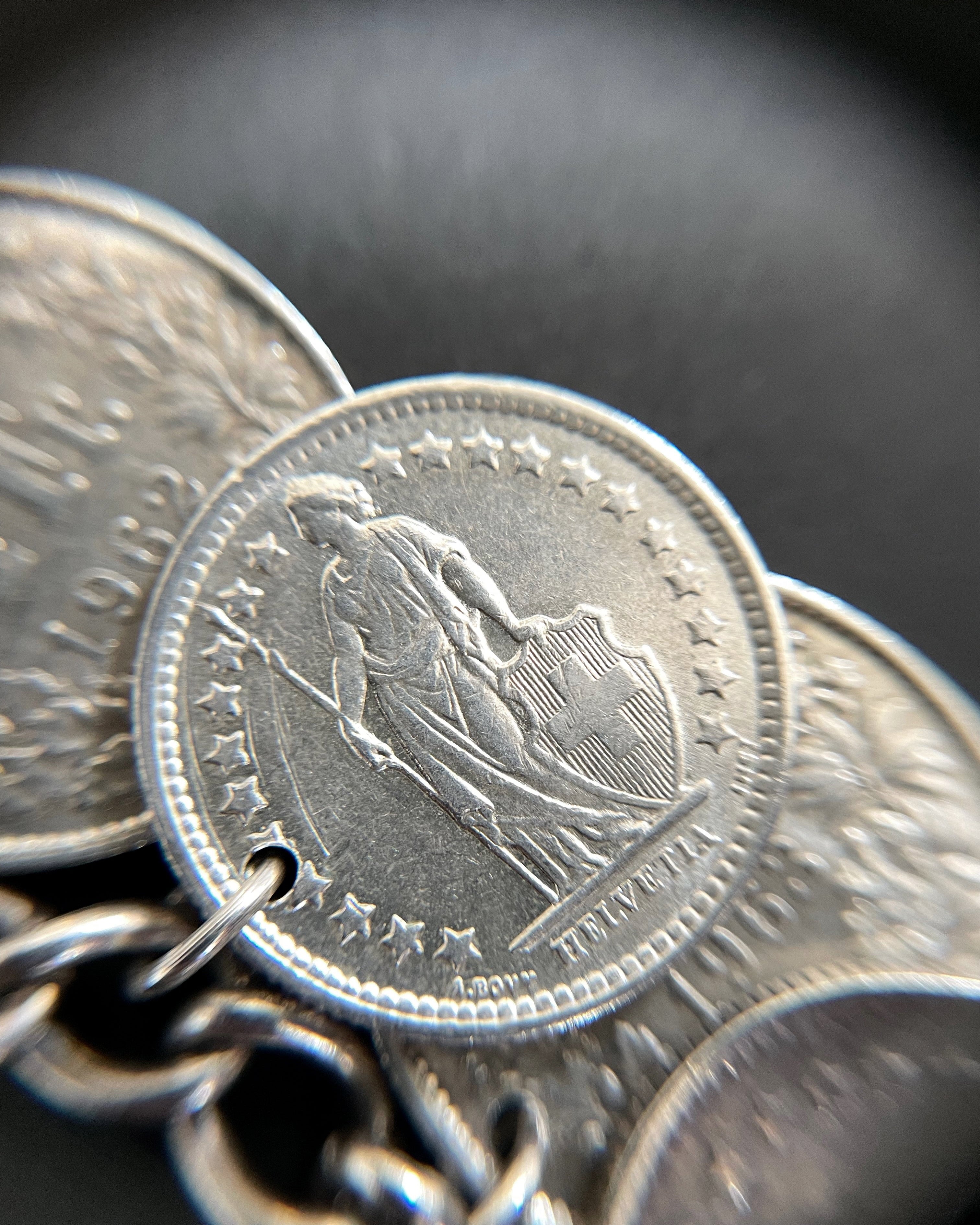 Close-up of vintage Swiss half-franc coin charm bracelet showing Standing Helvetia detail – Auric Vintage