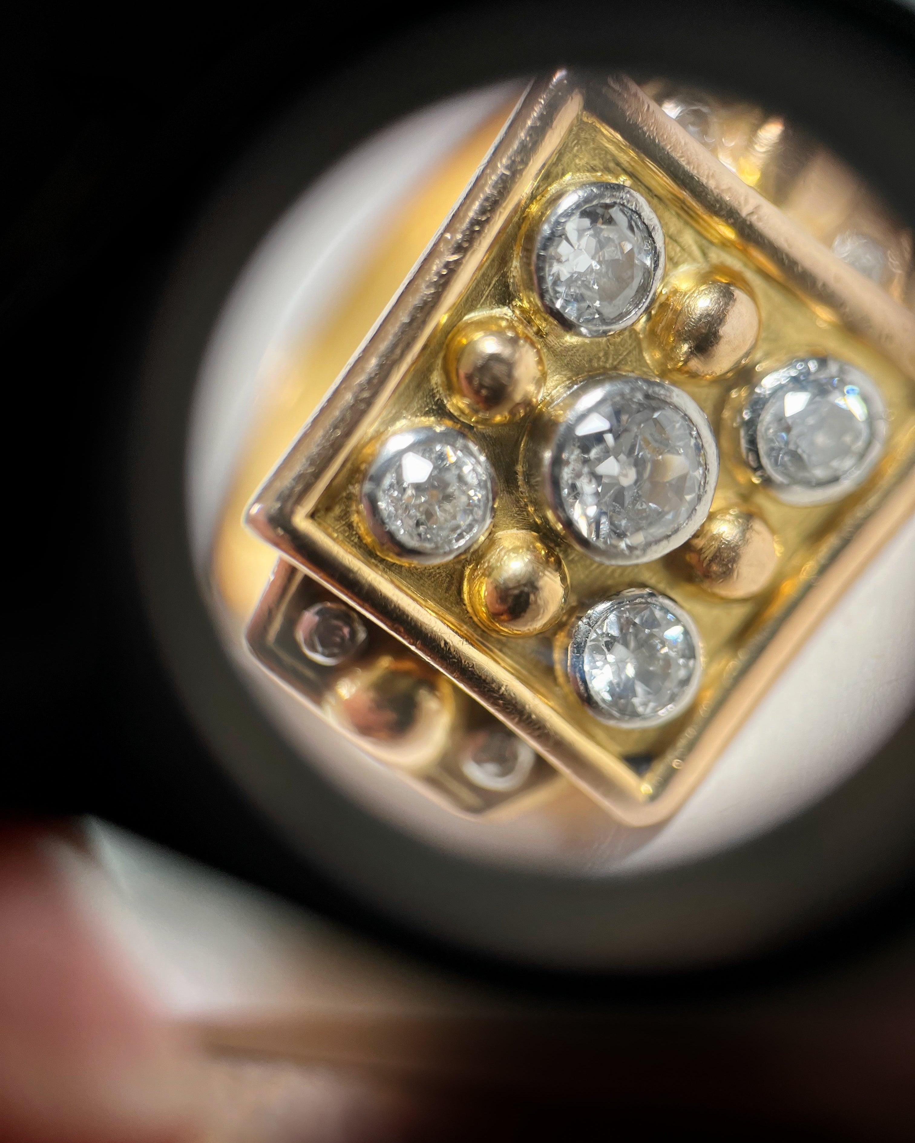 Close-up of retro French diamond ring through jeweller’s loupe showing diamond detail and setting – Auric Vintage