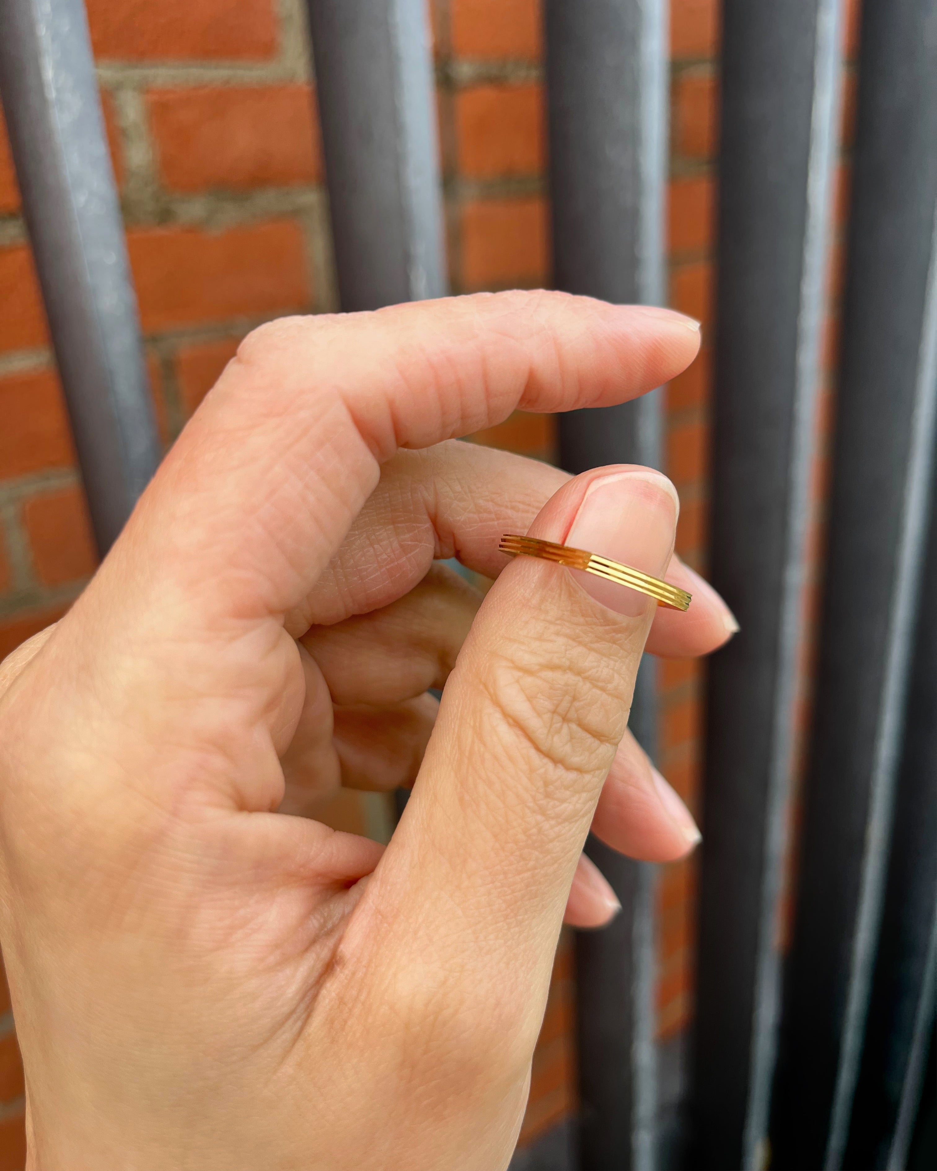 French quadrangular ribbed band in 18kt yellow gold held in a hand showing structured design – Auric Vintage
