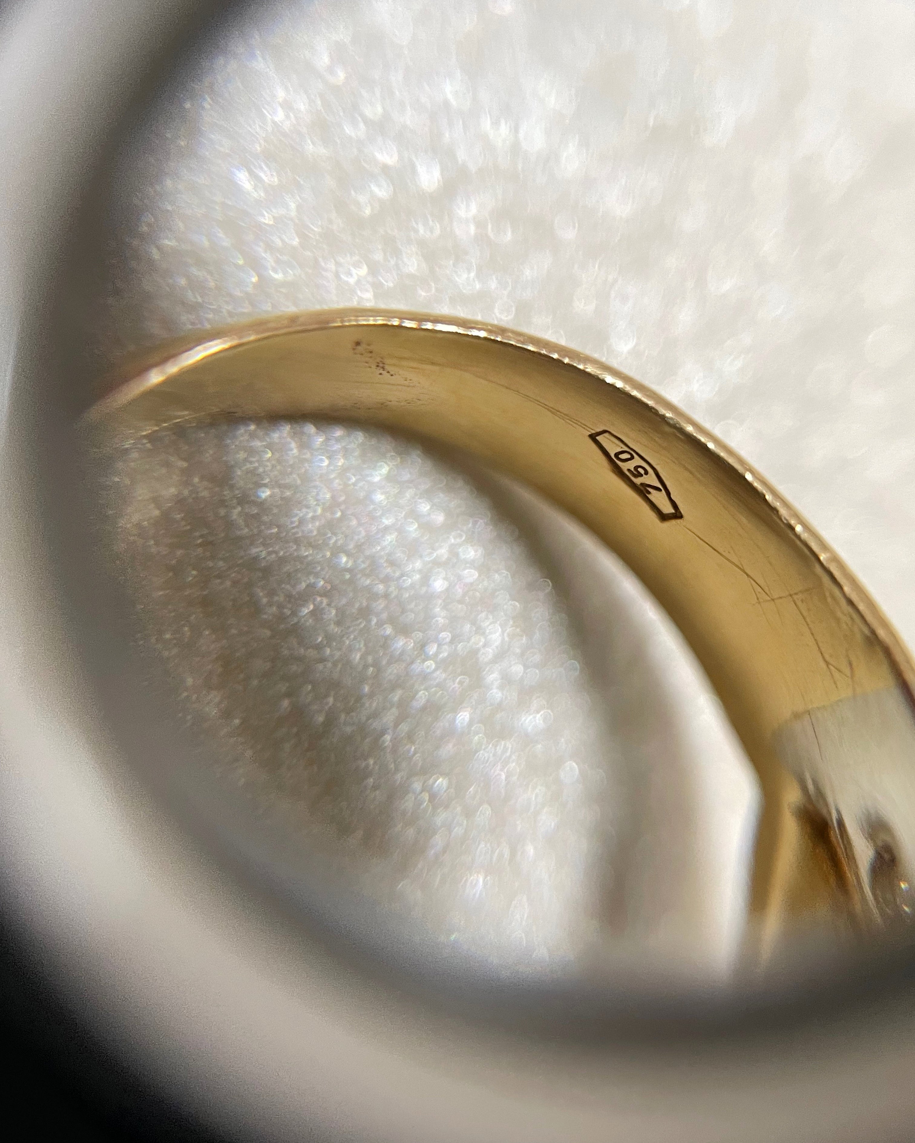 Close-up of noughties Italian diamond cluster bypass ring through jeweller’s loupe showing 750 gold hallmark – Auric Vintage