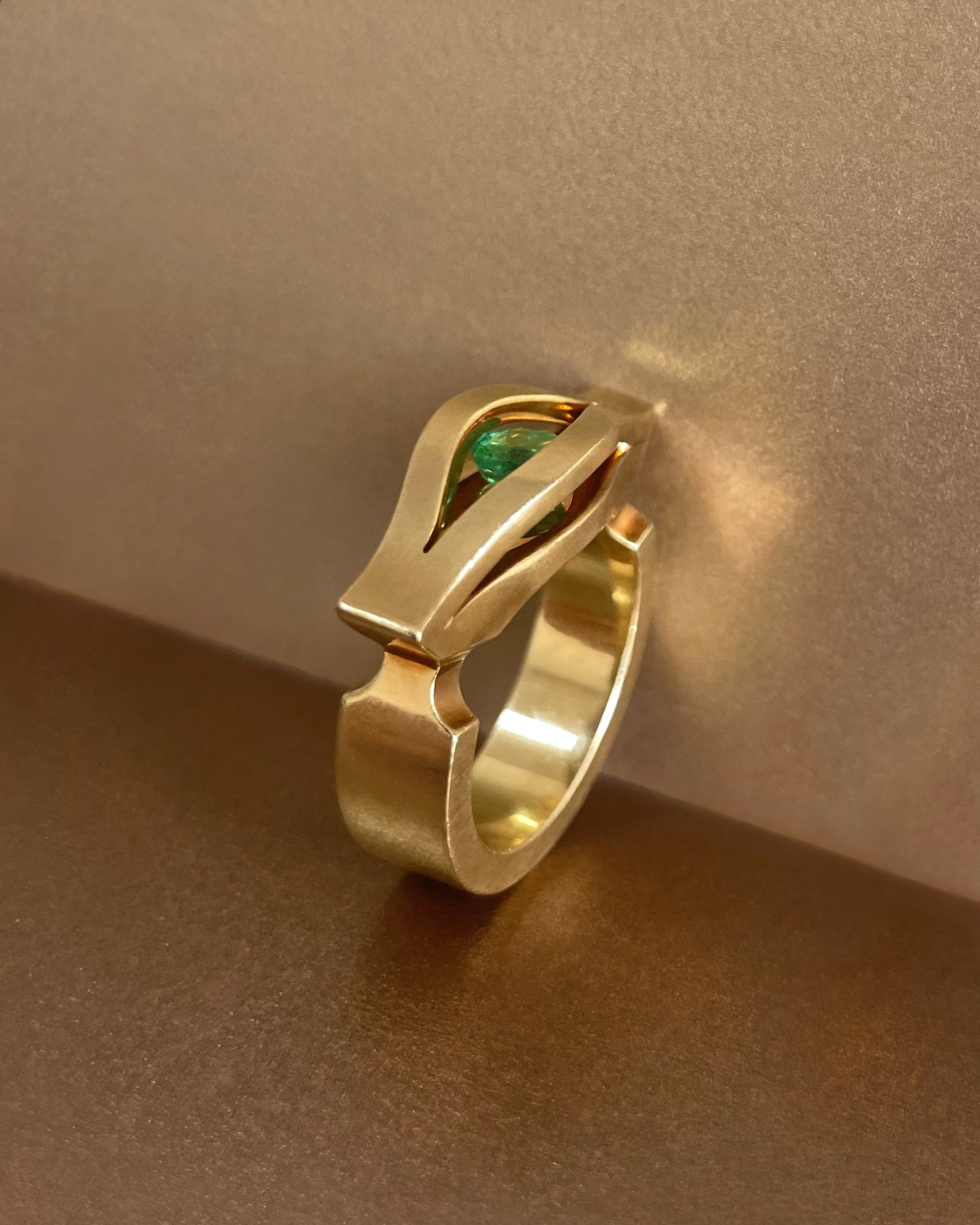Side view of modernist French emerald iris ring in 18kt yellow gold showing sculptural openwork profile – Auric Vintage