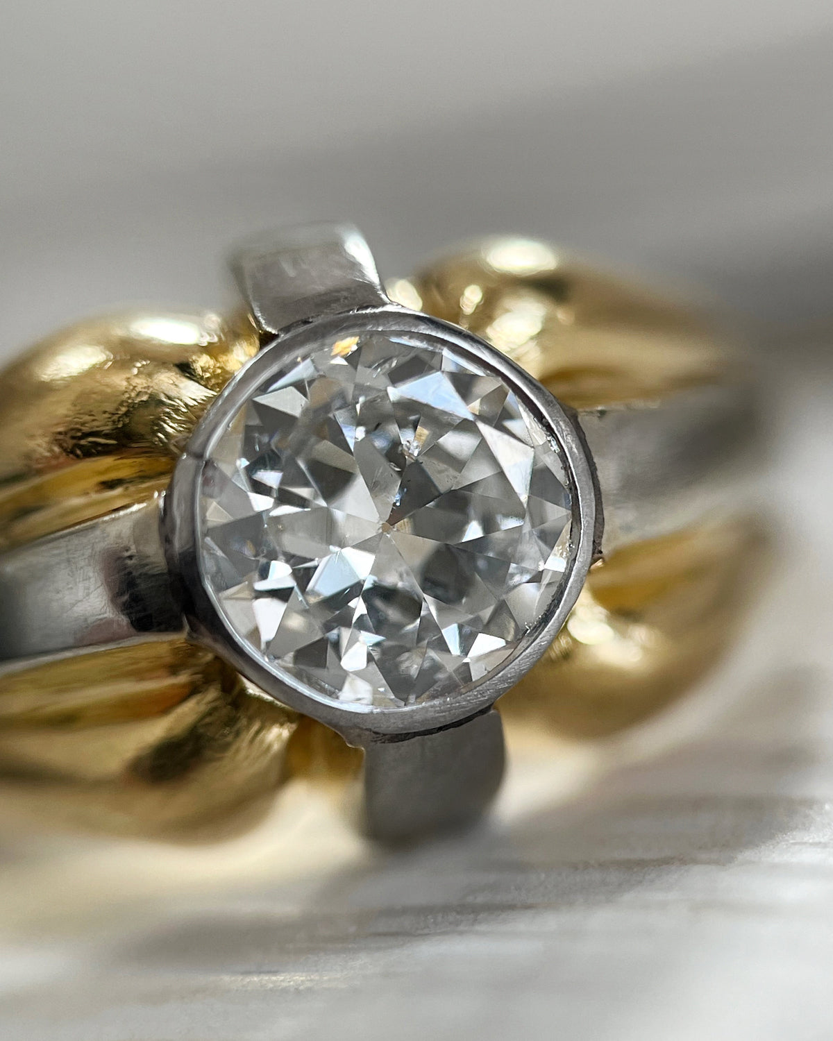 Magnified close-up of the 0.90ct Old European cut diamond in a finely detailed platinum millegrain setting, viewed through a jeweller's loupe.