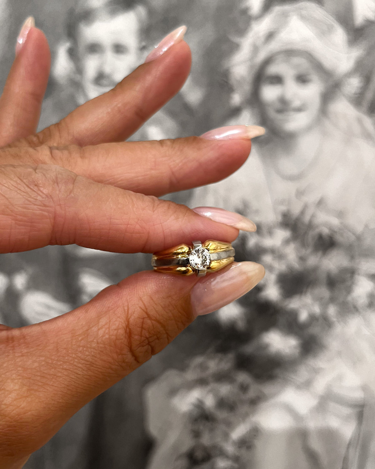 1990s vintage 18kt two-tone gold diamond solitaire engagement ring with 0.20ct Old European cut diamond in compass setting, held in hand