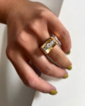 1940s vintage tank ring set with five graduating Old Mine cut diamonds in four-claw settings, shown on a hand against a white wall.
