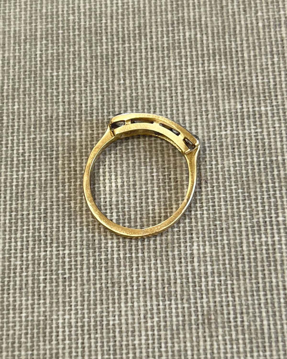 Top view of an antique five-stone diamond ring showing five graduating cushion-shaped Old Mine cut diamonds and the linear openwork gallery beneath the stones.