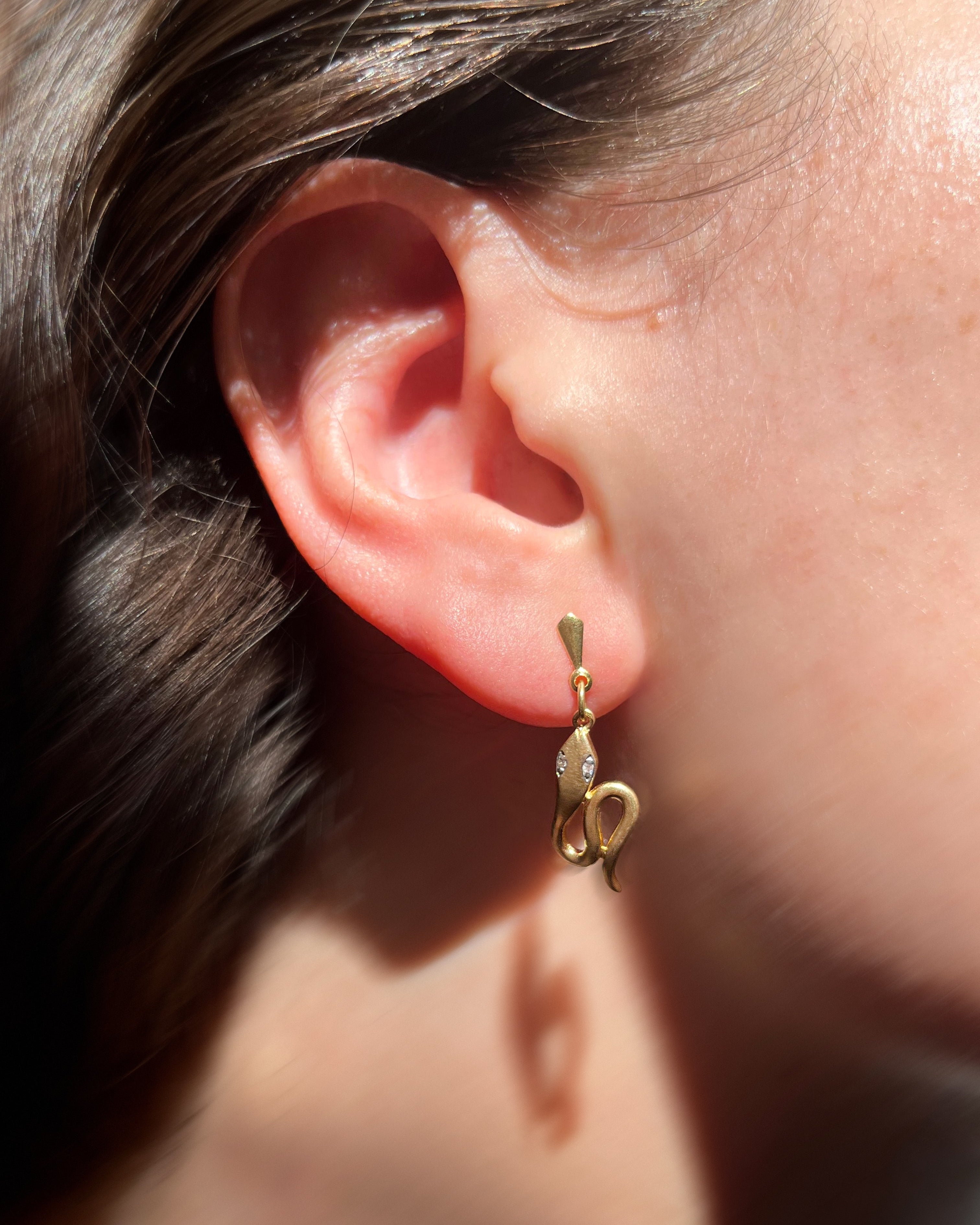 Contemporary twin serpent diamond drop earrings in 18kt yellow gold, worn on an ear – Auric Vintage