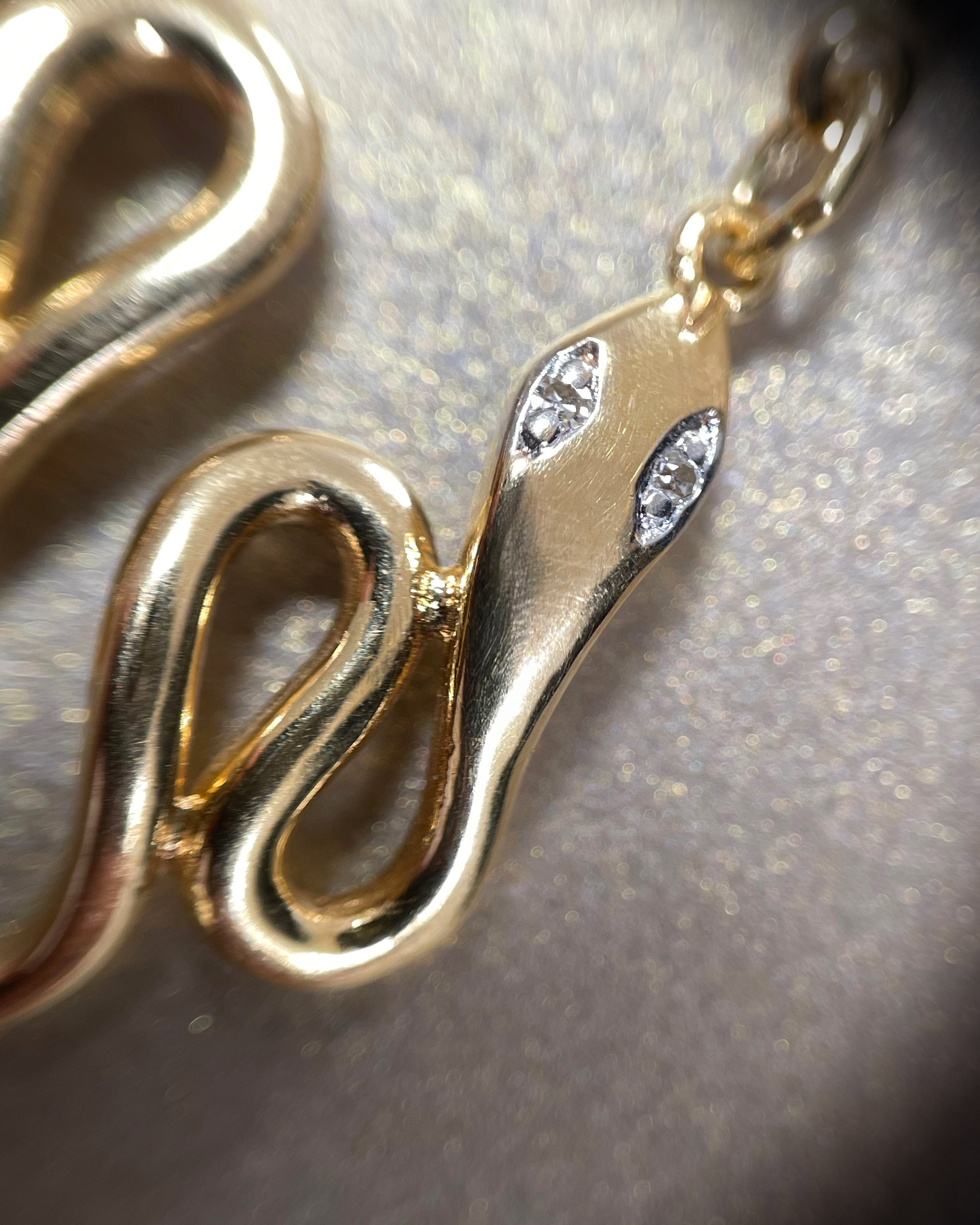 Close-up of contemporary 18kt yellow gold twin serpent diamond drop earrings showing sculptural detail and diamond eyes – Auric Vintage