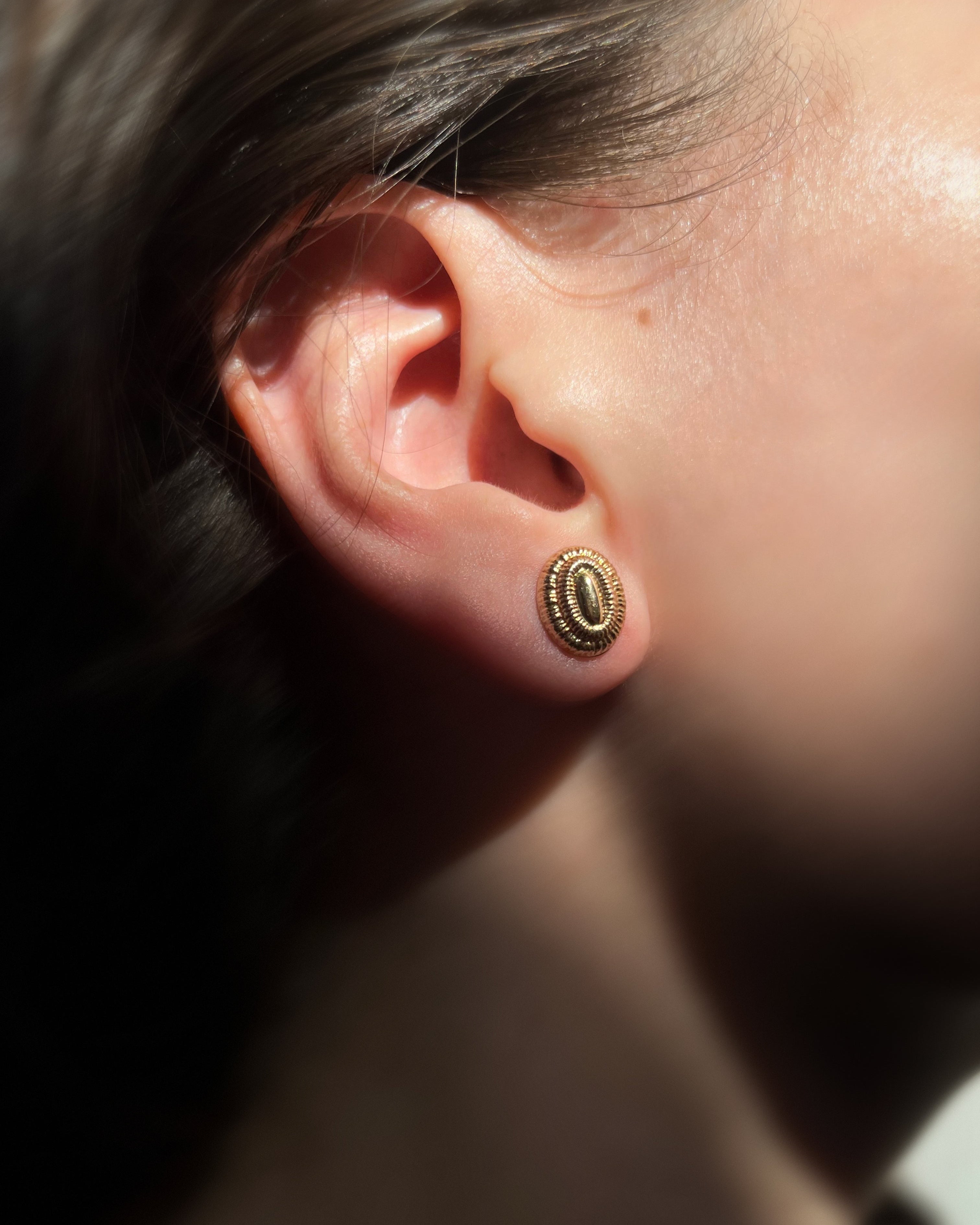 Seventies oval ribbed terraced stud earrings in 9kt yellow gold worn on the ear – Auric Vintage
