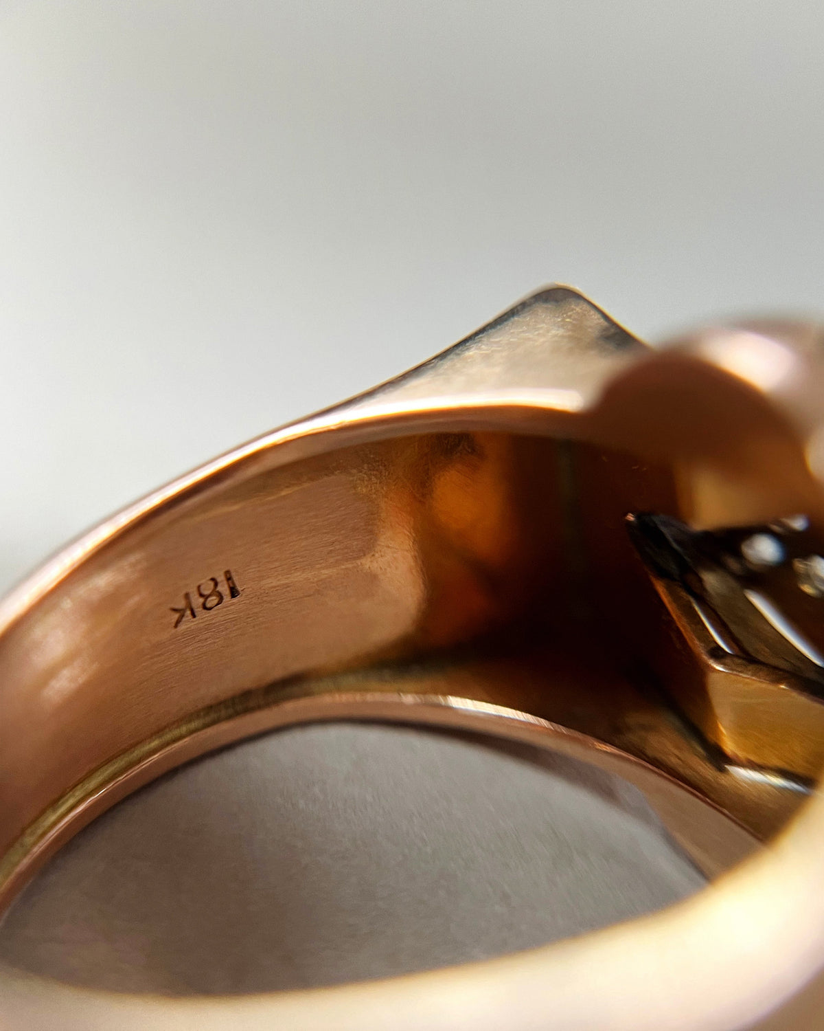 Close-up of the interior of a 1940s vintage tank ring showing the 18KT mark inside the band.