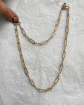 1970s textured paperlink chain in 9kt yellow gold held on finger showing elongated links and rope twist detail – Auric Vintage