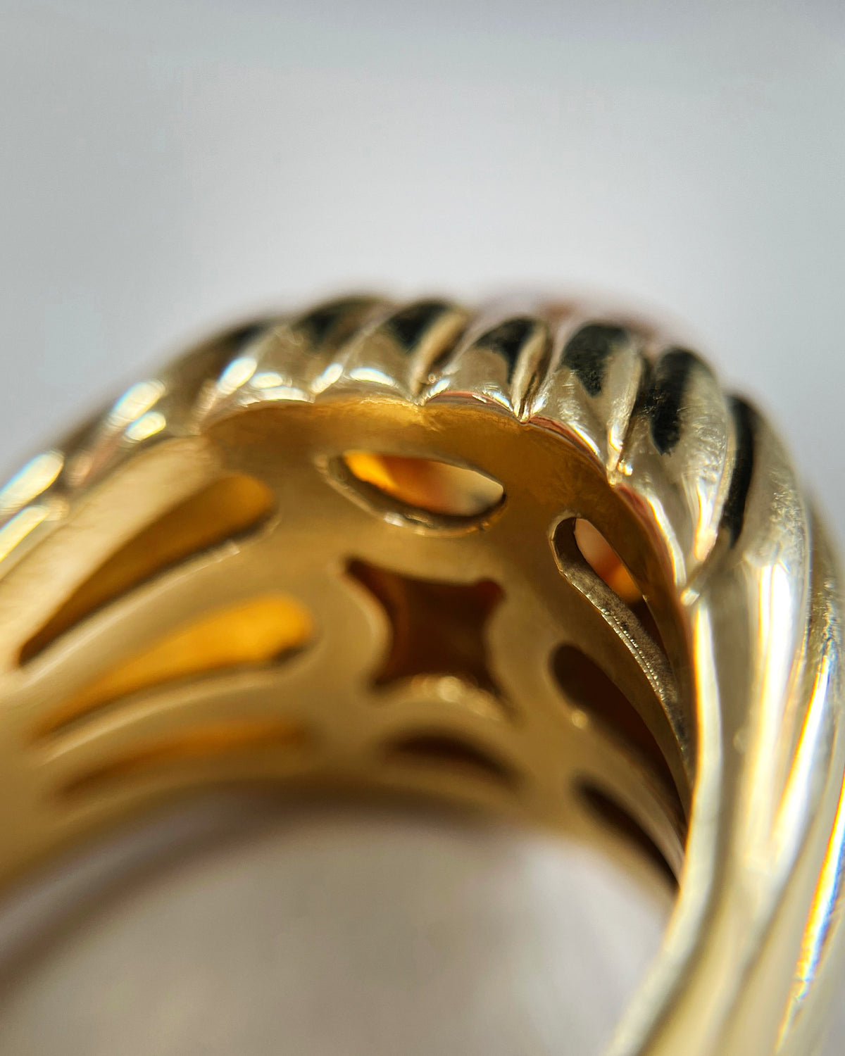 Close-up of the interior of a vintage 18kt gold citrine statement ring, showing the sculptural setting and ribbed detailing continuing around the reverse.