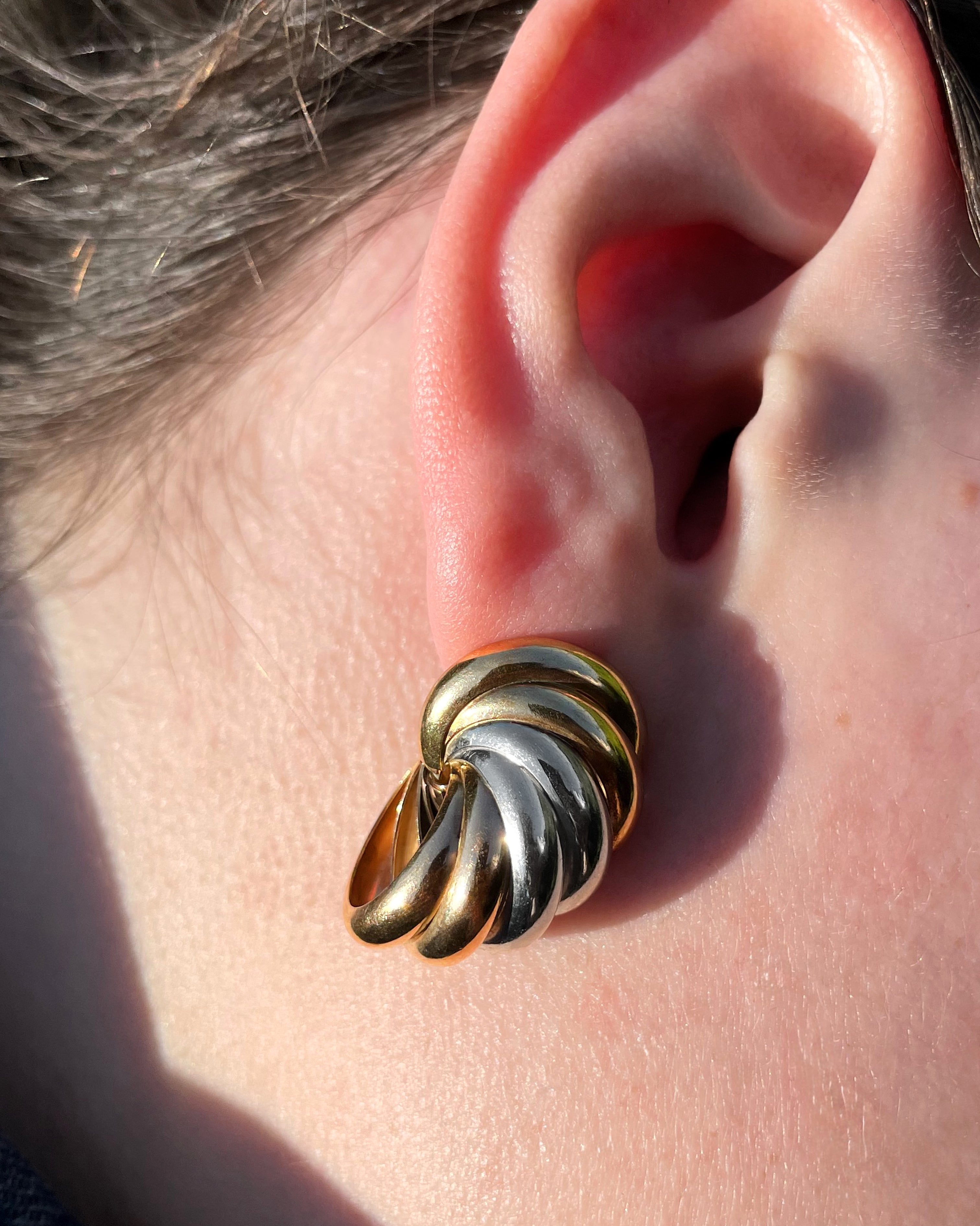 Seventies tri-gold spiral hoop earrings in 9kt gold worn on ear showing scale and twisted gold detail – Auric Vintage