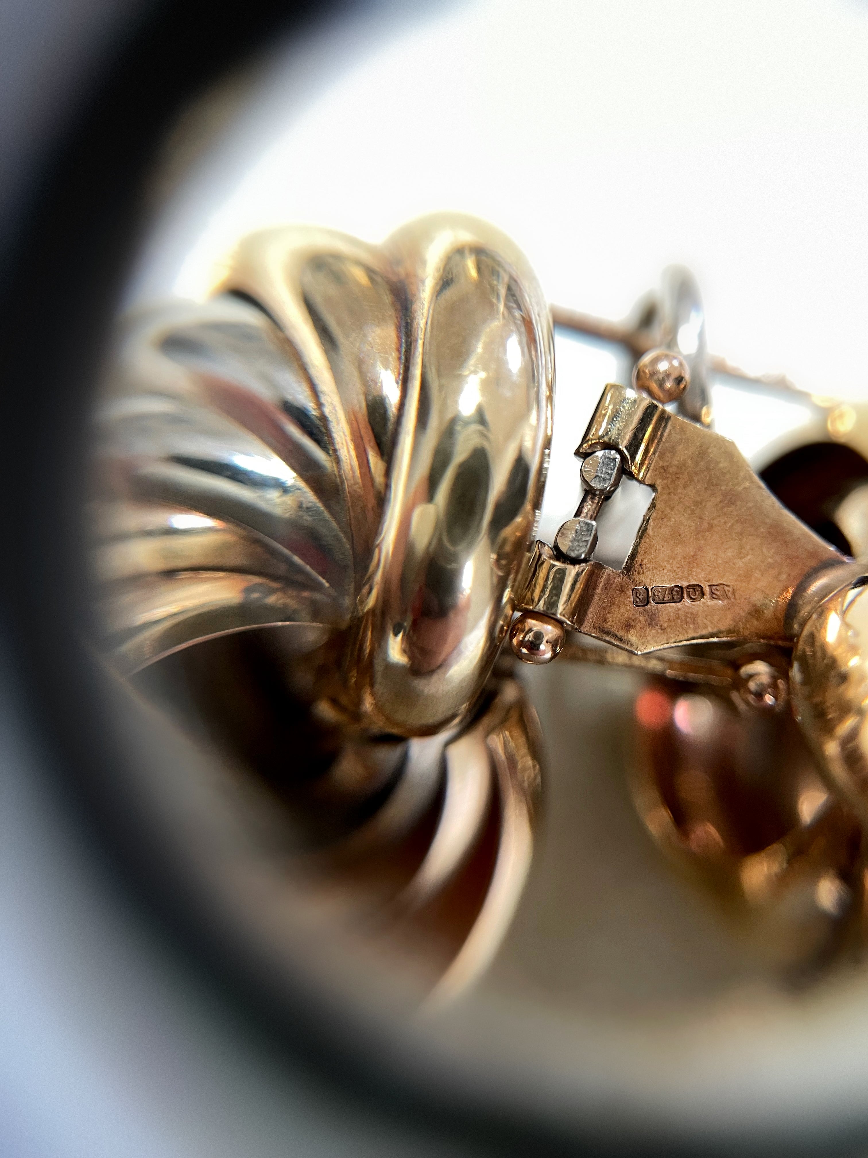 Close-up of seventies tri-gold spiral hoop earrings showing 375 gold hallmark – Auric Vintage