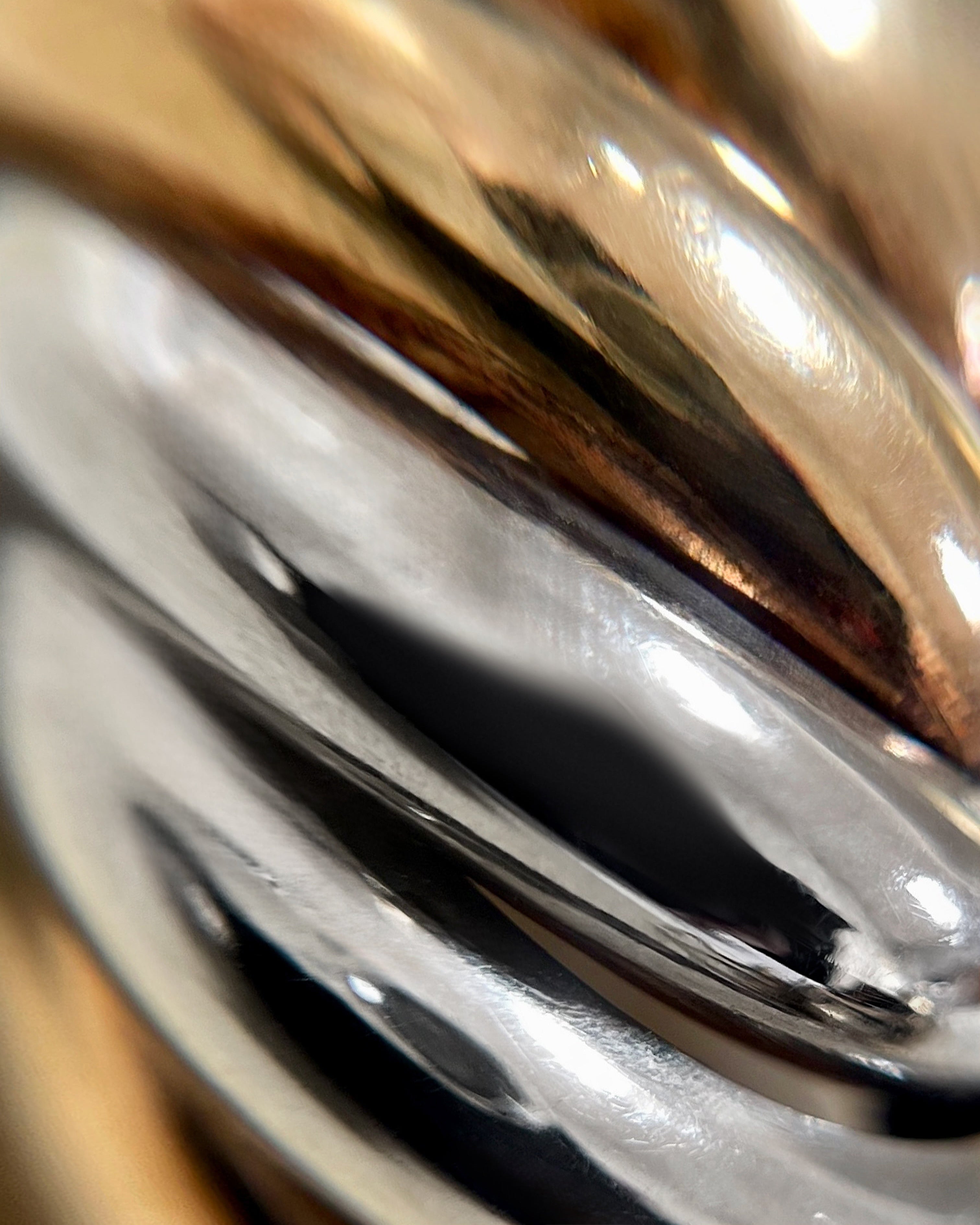 Close-up of seventies tri-gold spiral hoop earrings in 9kt gold showing twisted ribbed detail – Auric Vintage