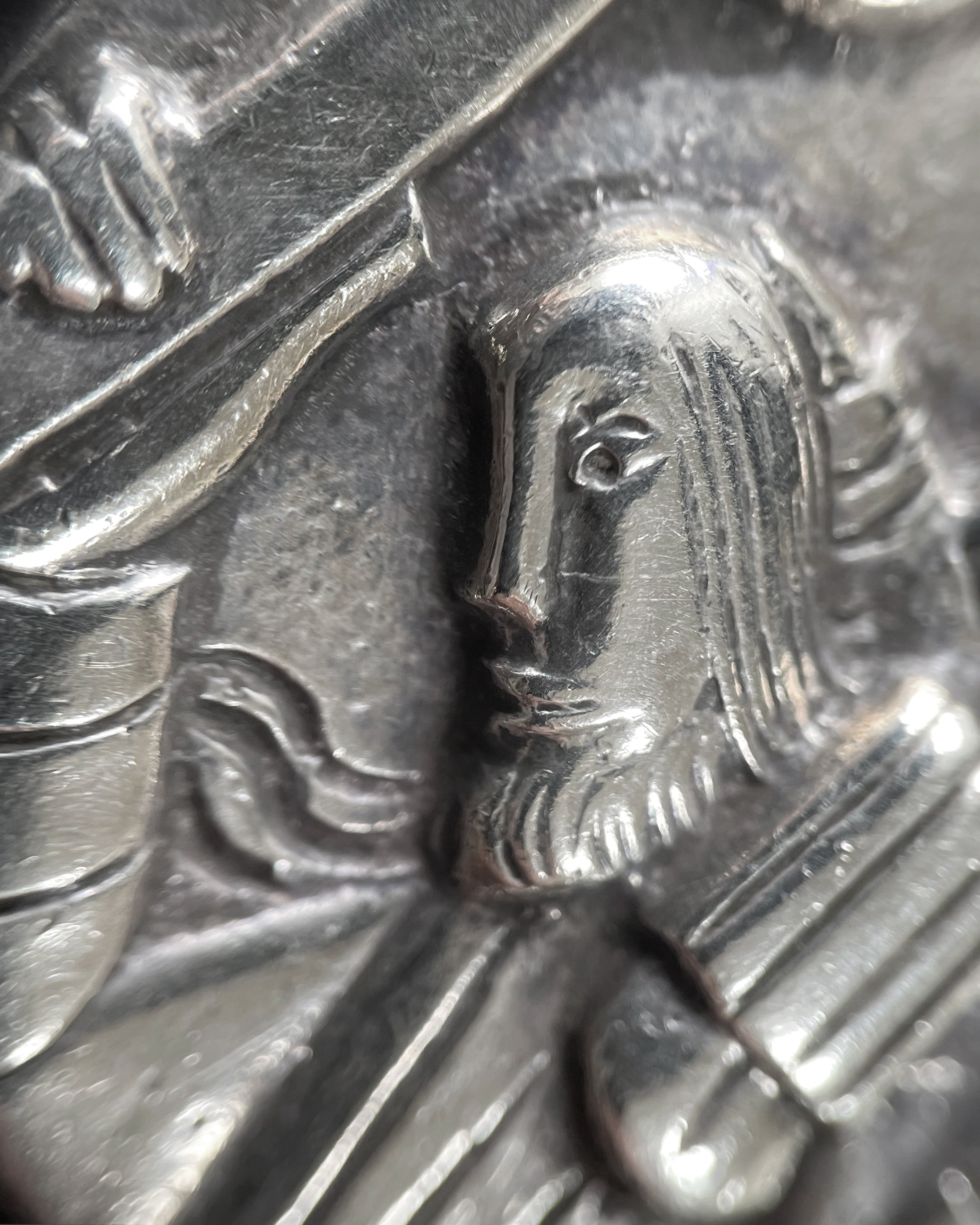 Close-up of 1970s sterling silver St. Christopher medallion showing relief detail – Auric Vintage