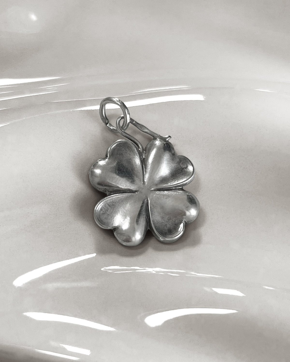 Antique Austro-Hungarian 750 silver lucky four-leaf clover pendant with sculptural undulating leaves and curling stem.
