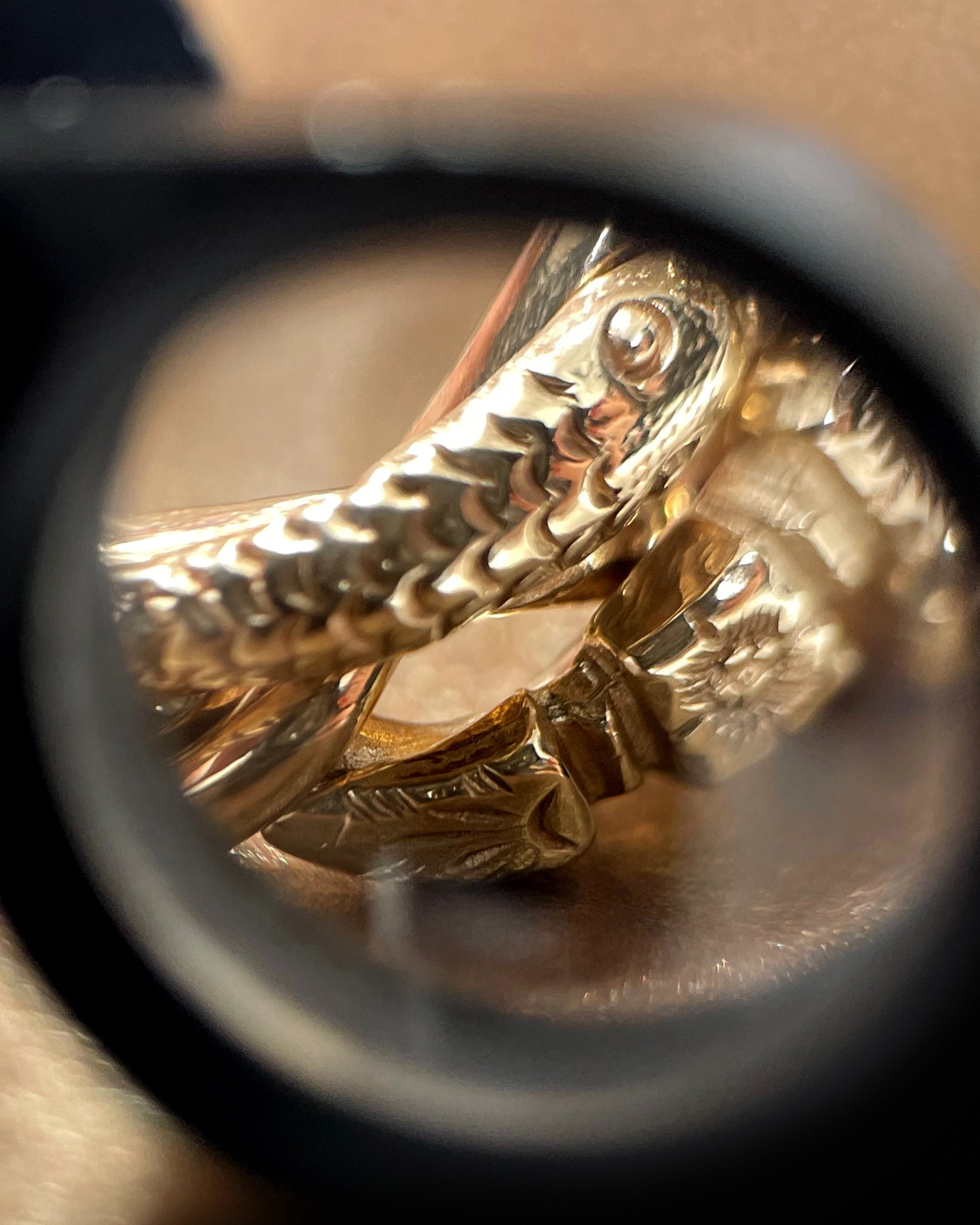 Close-up of engraved serpent motif on vintage British 9kt yellow gold puzzle ring – Auric Vintage