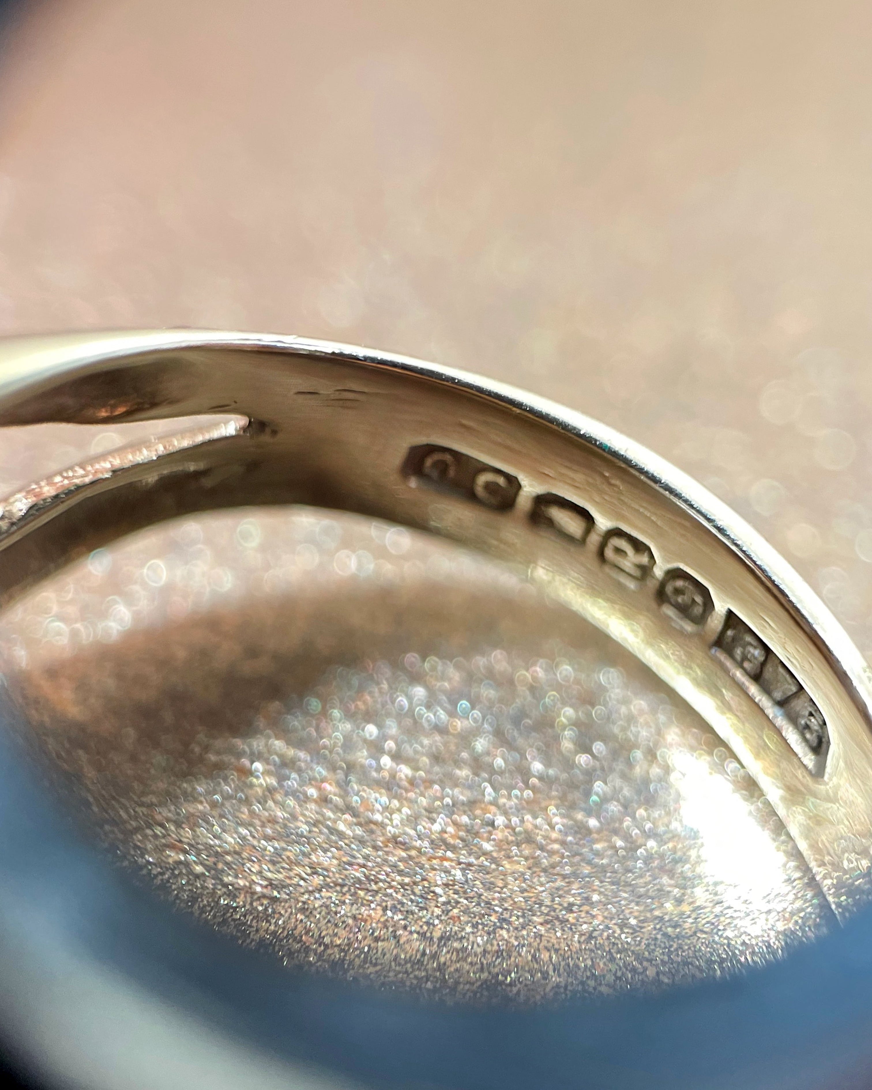 Close-up of Dublin 1982 hallmarks inside Eighties 9kt yellow gold crossover knot ring – Auric Vintage