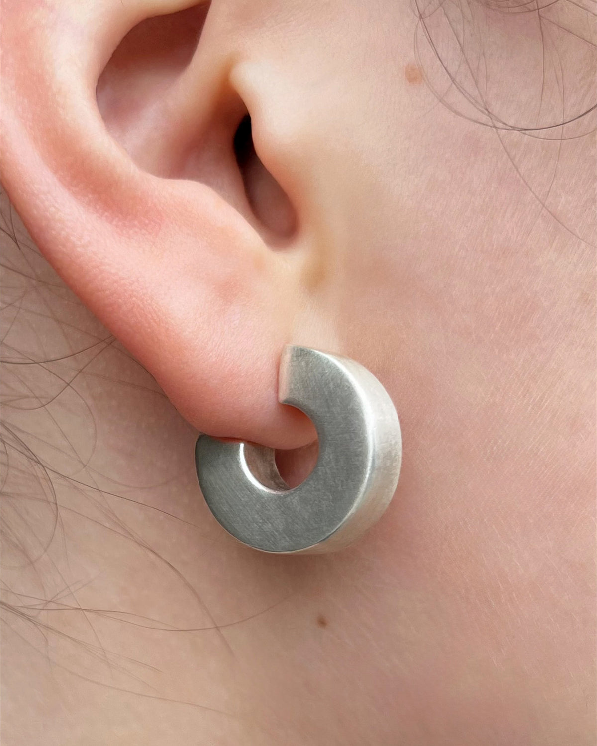 Vintage Sterling silver statement hoop earring with a chunky square-edged design and polished finish, worn on the ear.