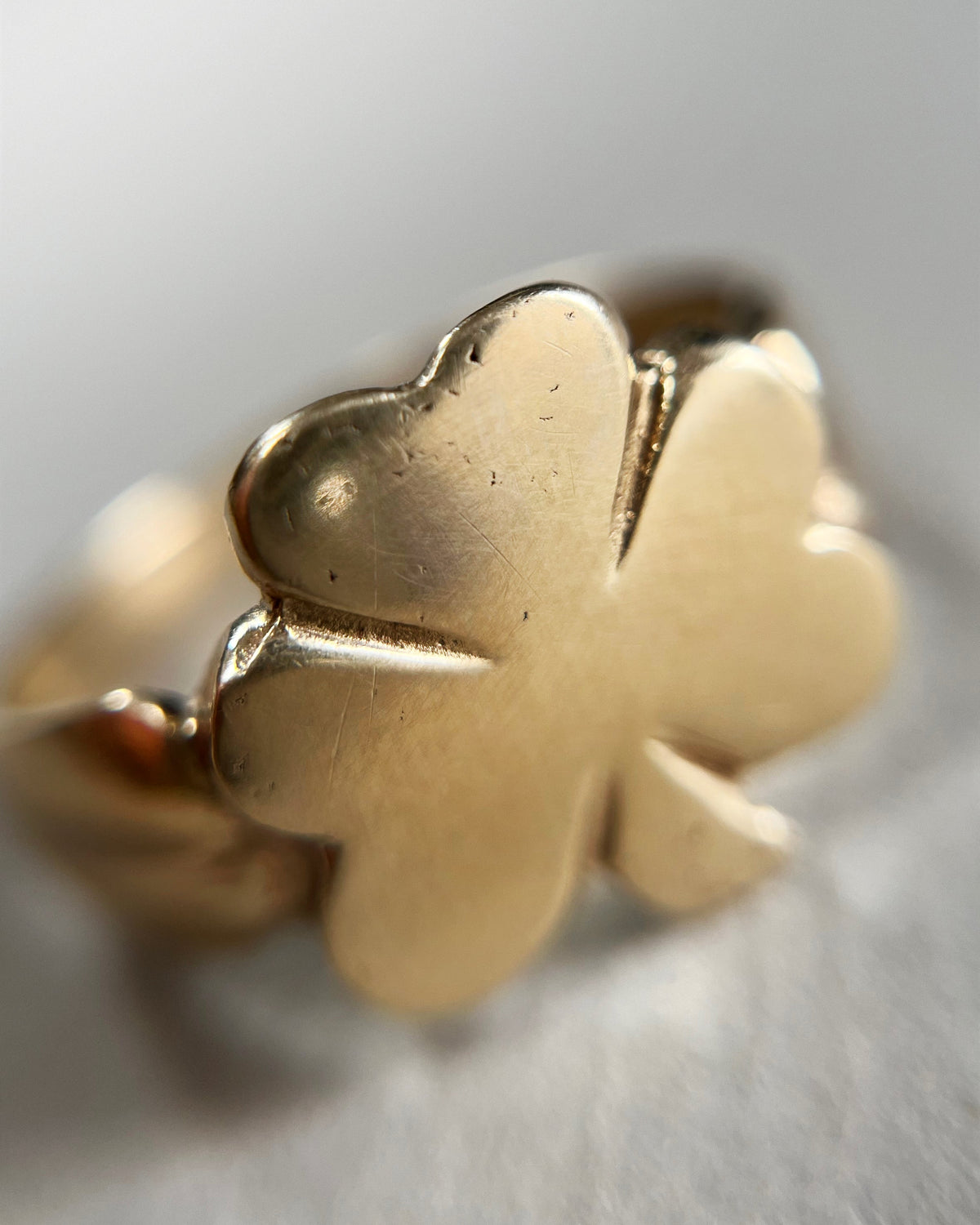 Magnified view of the polished shamrock motif on a 1970s vintage Irish 9kt gold ring.
