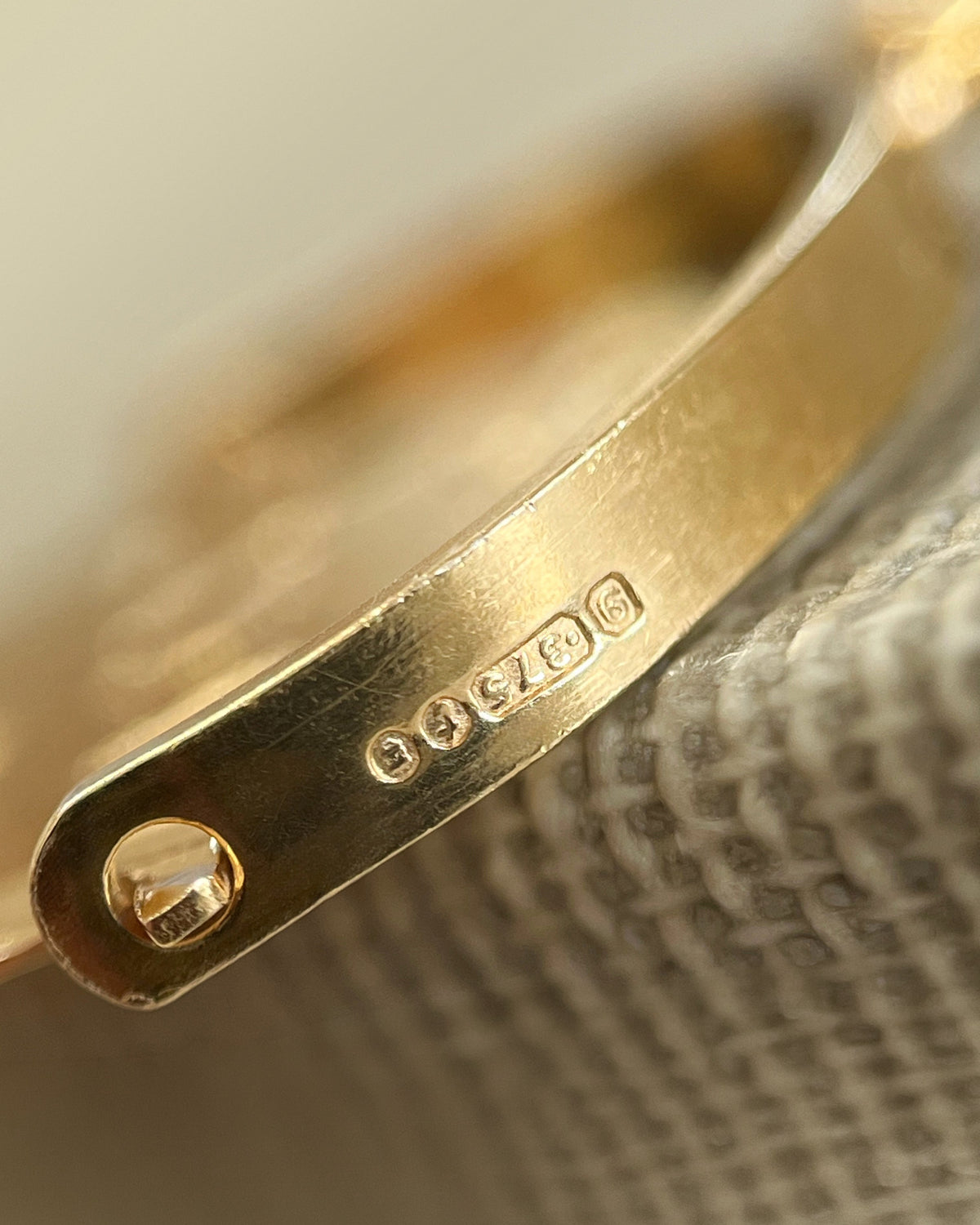 Close-up of the London hallmark and 9kt gold marks on a vintage 1970s “I Love You” pendant.