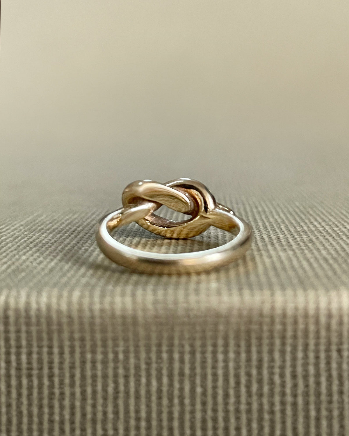 Reverse view of two vintage Irish 9kt gold knot rings showing their individual bands and overhand knot design.