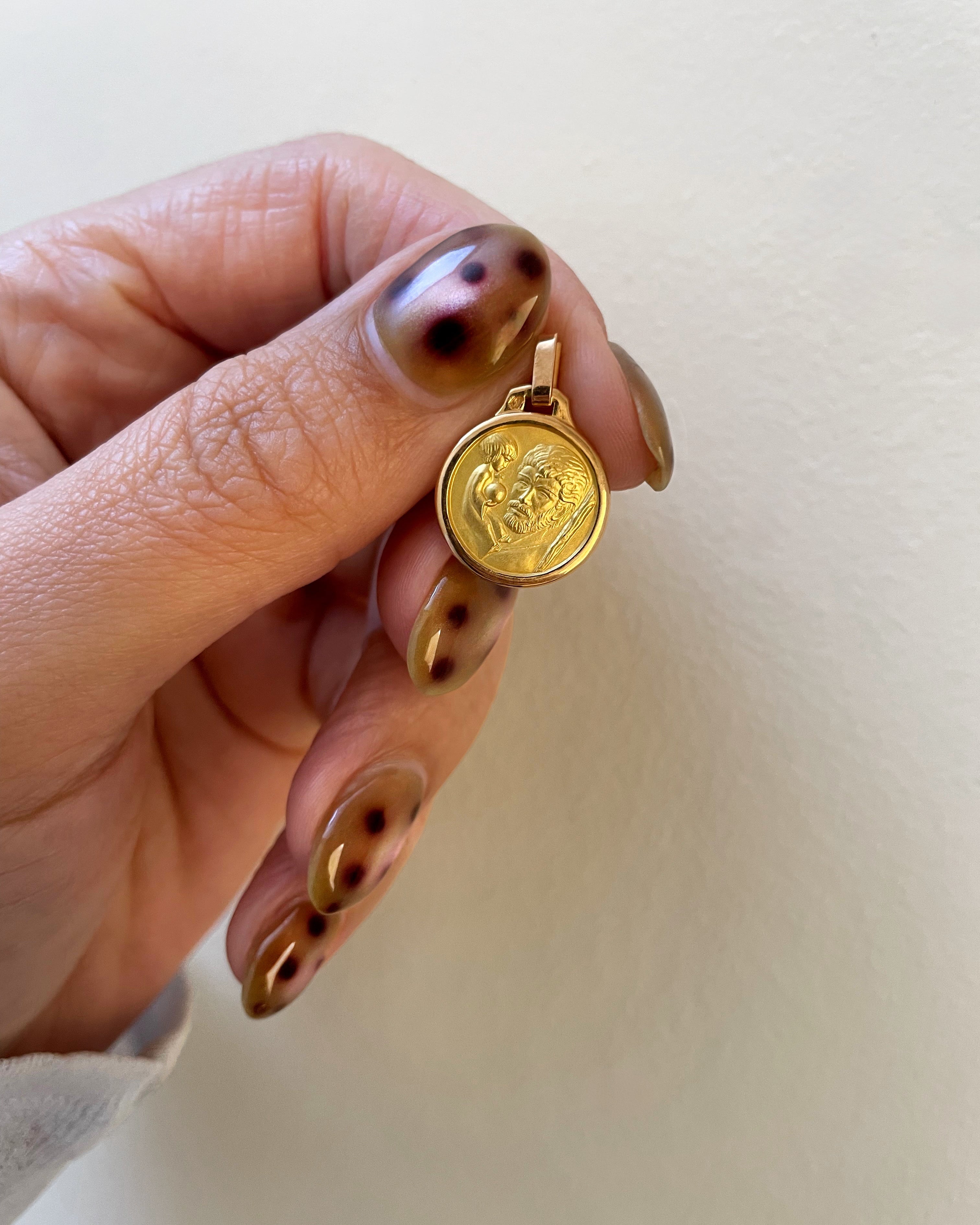 Late 20th century mini St. Christopher medallion in 18kt yellow gold held in hand showing scale and figural detail – Auric Vintage