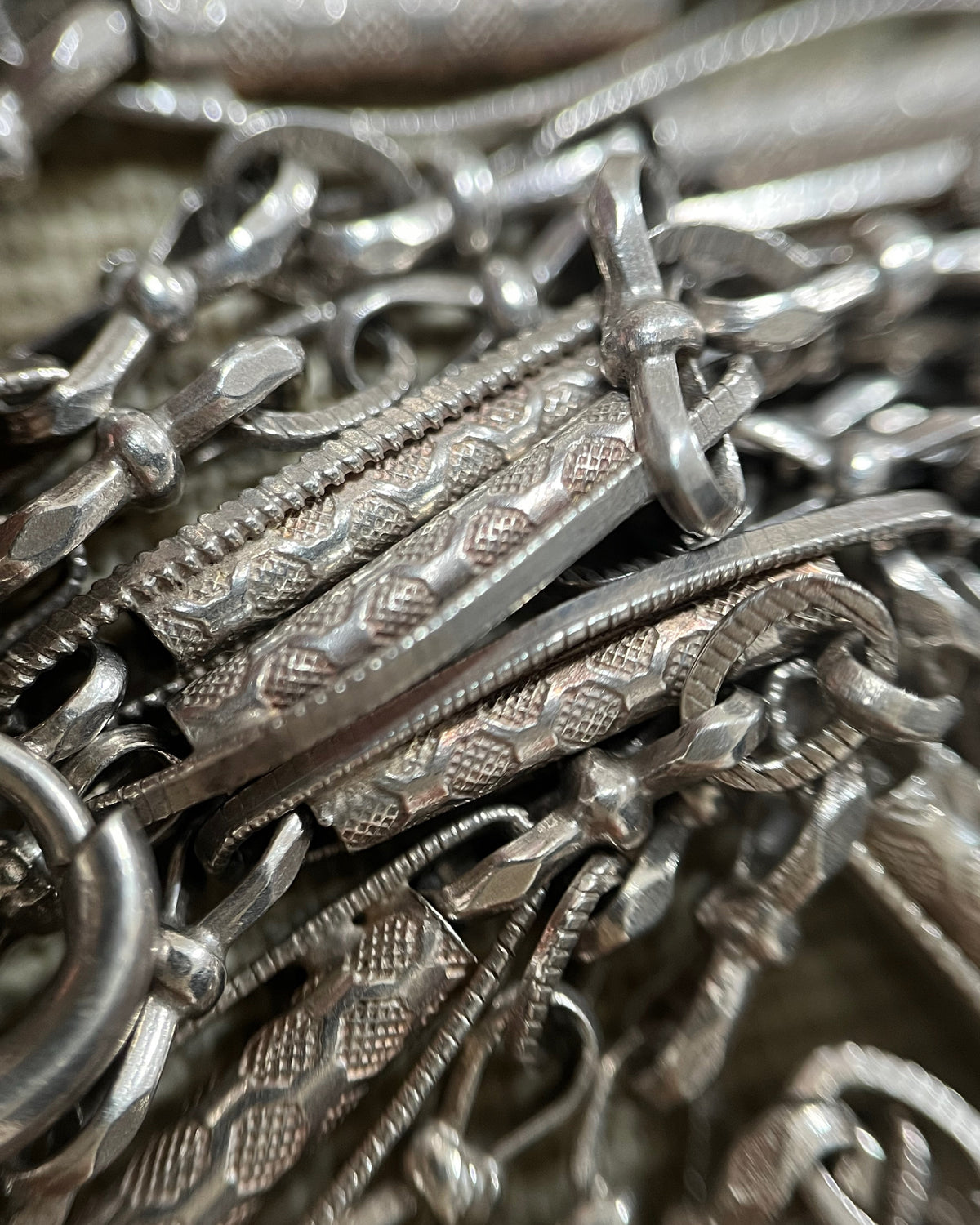 Close-up of the decorative open marquise, bow and belcher links on a Belle Époque French antique 800 silver sautoir necklace.