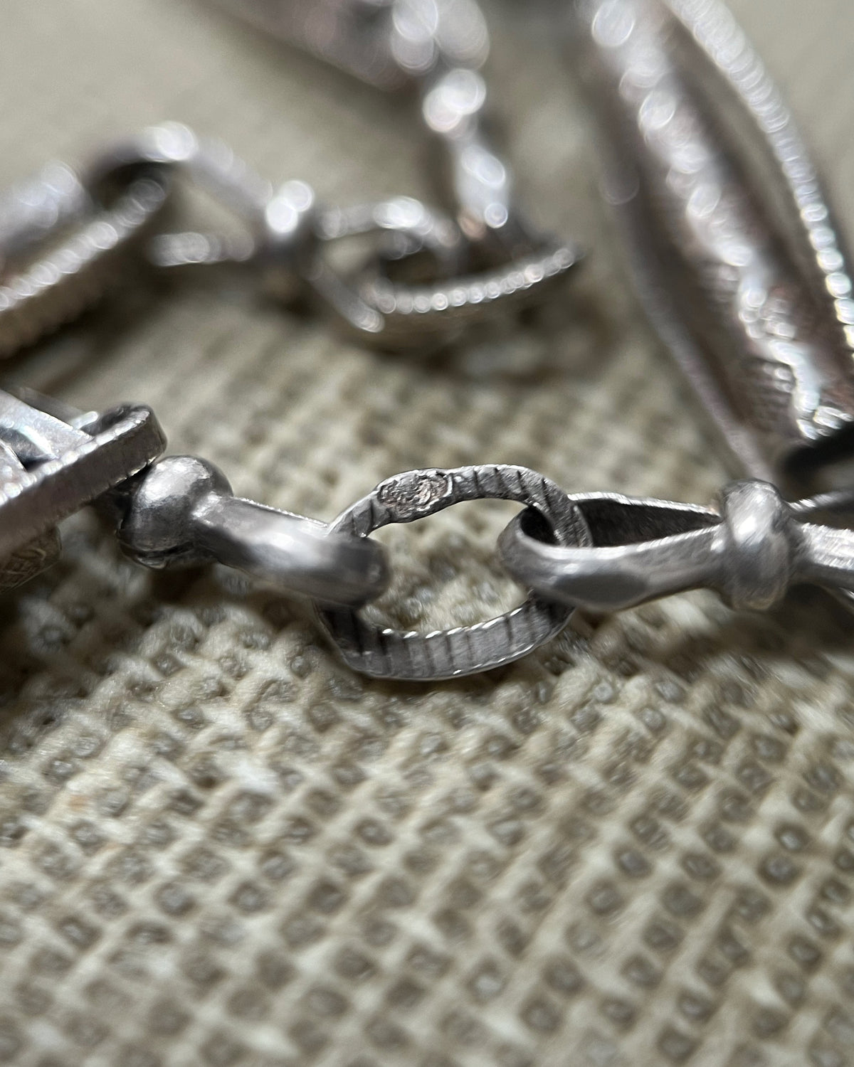 Magnified close-up of the French crab hallmark for 800 silver on an antique Belle Époque sautoir necklace, viewed through a jeweller's loupe.