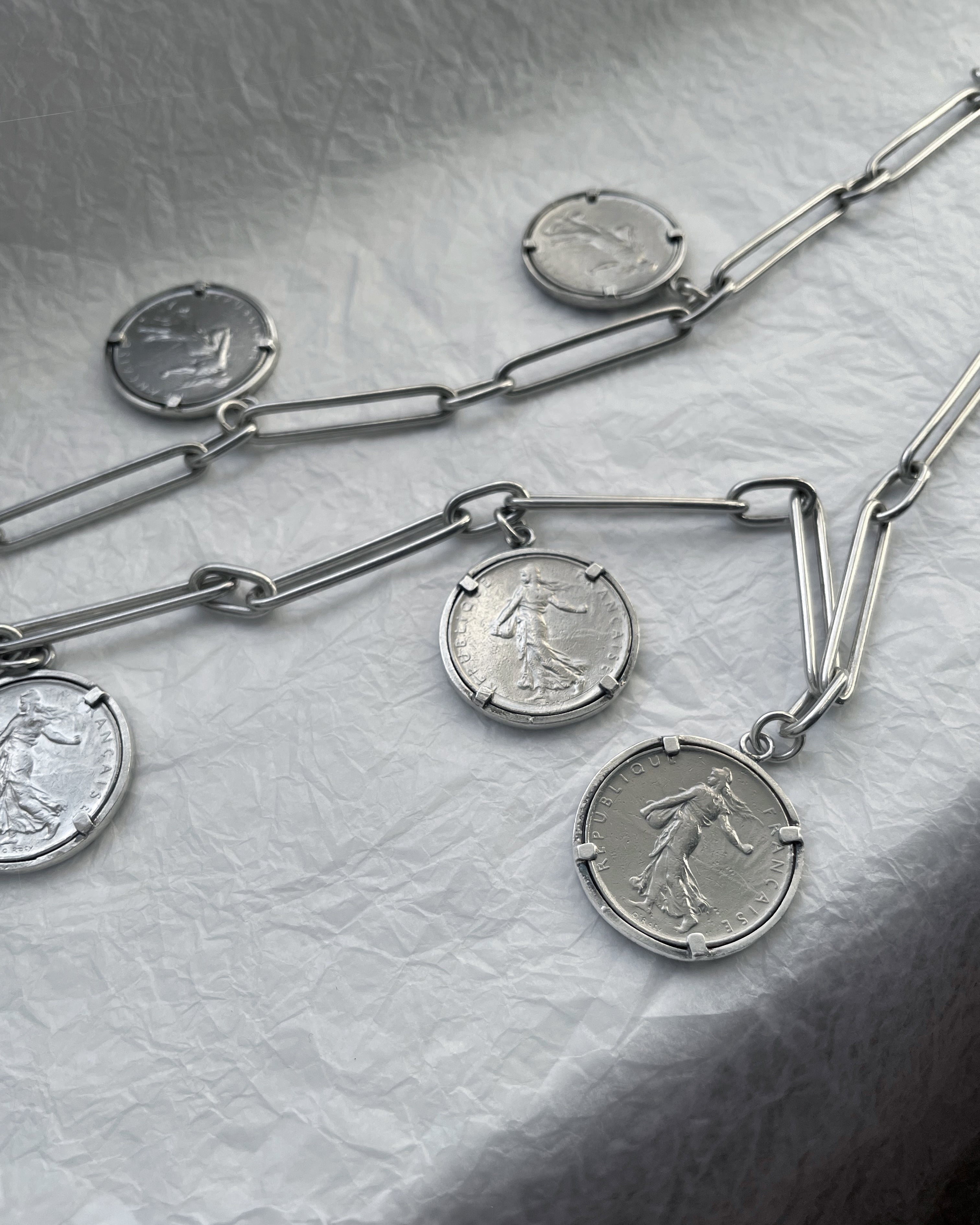 Arthus Bertrand 1 Franc coin sautoir in sterling silver laid on white background – Auric Vintage