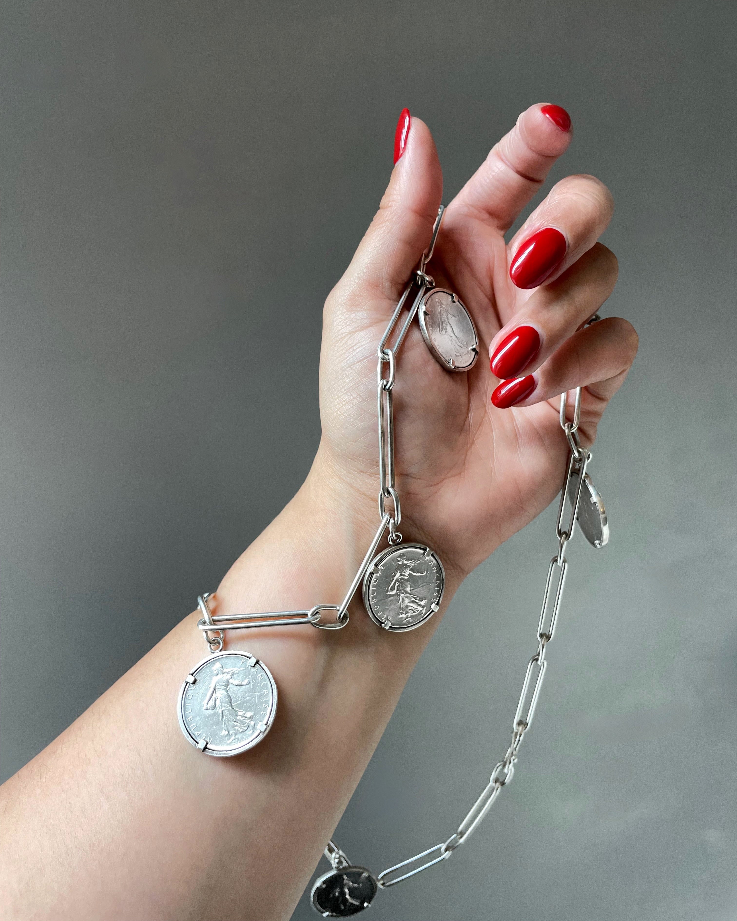 Arthus Bertrand 1 Franc coin sautoir in sterling silver held in hand showing scale and coin detail – Auric Vintage