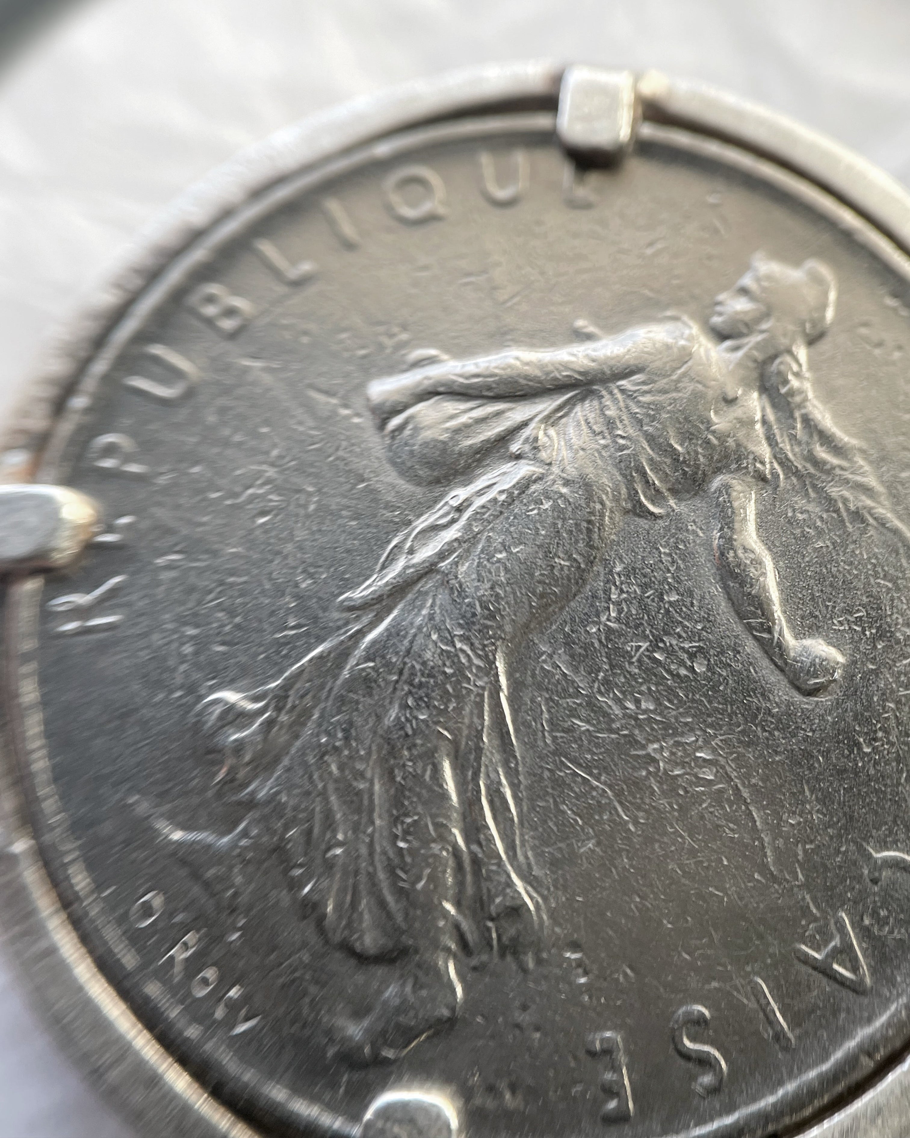 Close-up of Arthus Bertrand sterling silver 1 Franc coin sautoir showing Marianne side of French franc coin – Auric Vintage
