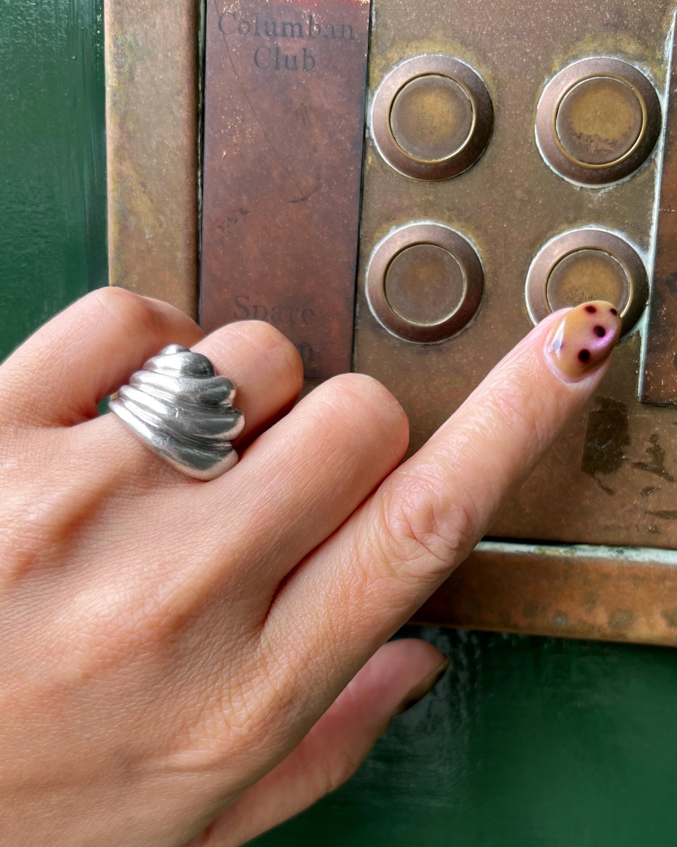 1970s ribbed wave ring in sterling silver worn on hand pressing doorbell showing scale and sculptural form – Auric Vintage