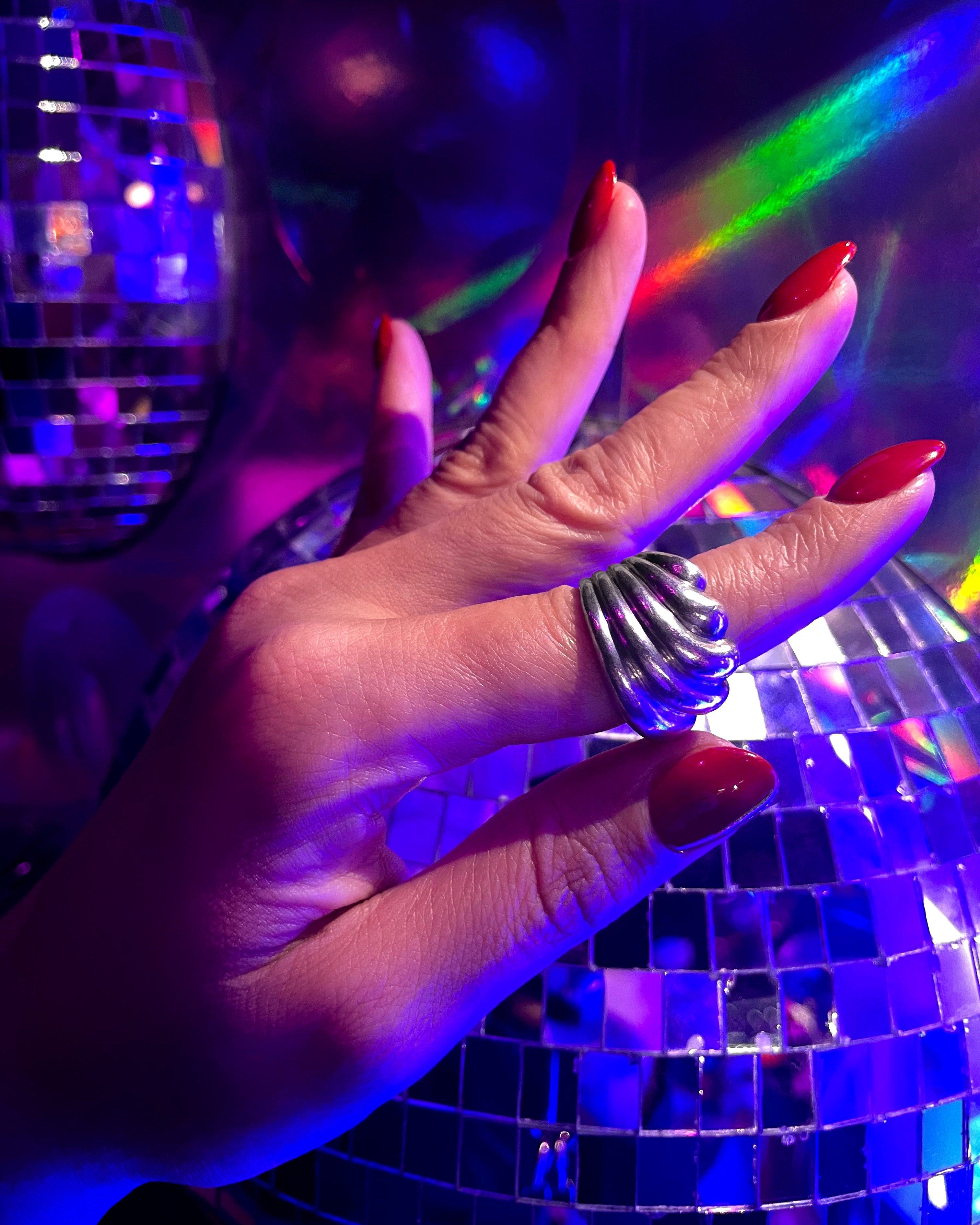 Seventies ribbed wave ring in sterling silver worn on hand with disco ball background – Auric Vintage