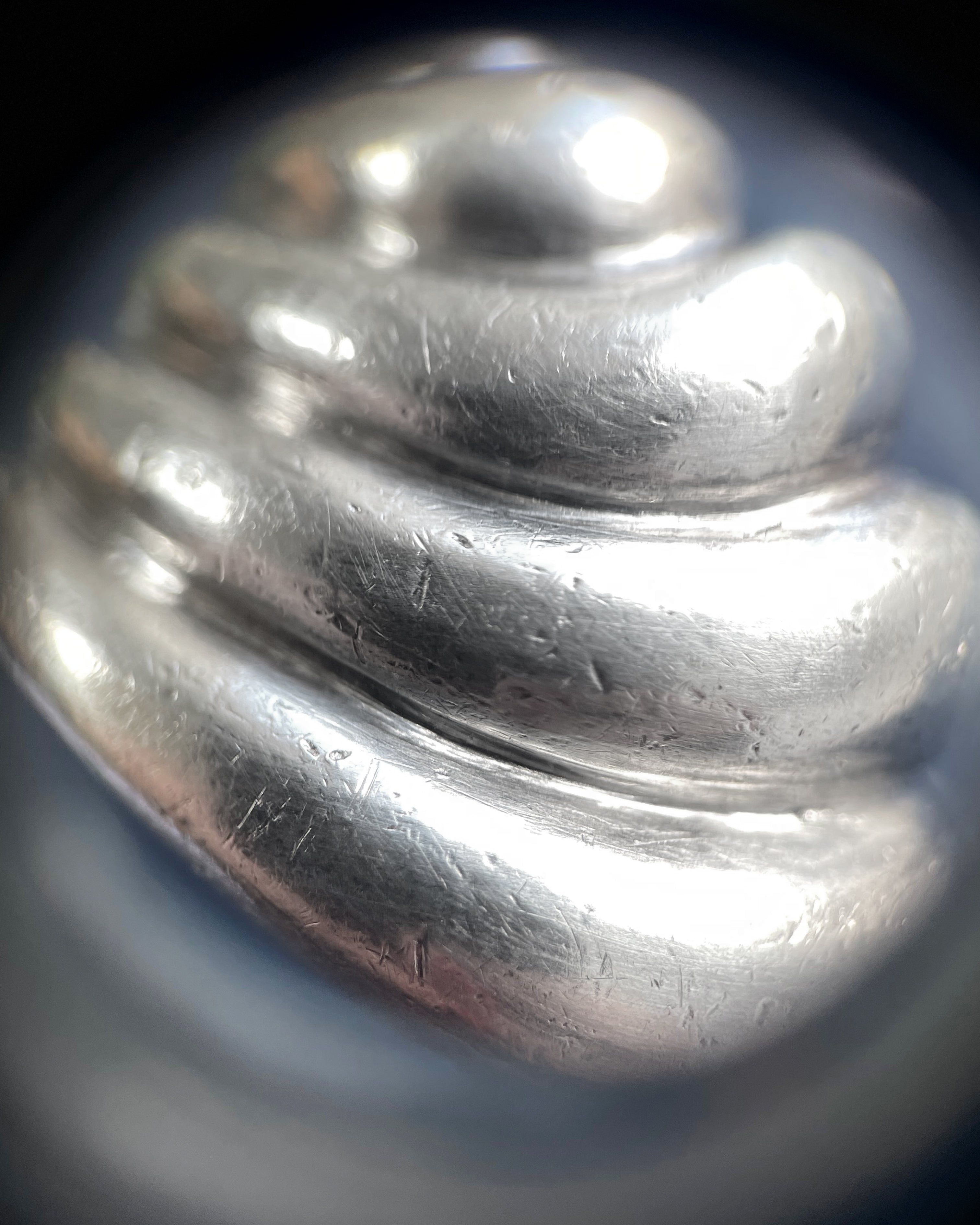 Close-up of seventies sterling silver ribbed wave ring through jeweller’s loupe showing ribbed texture – Auric Vintage