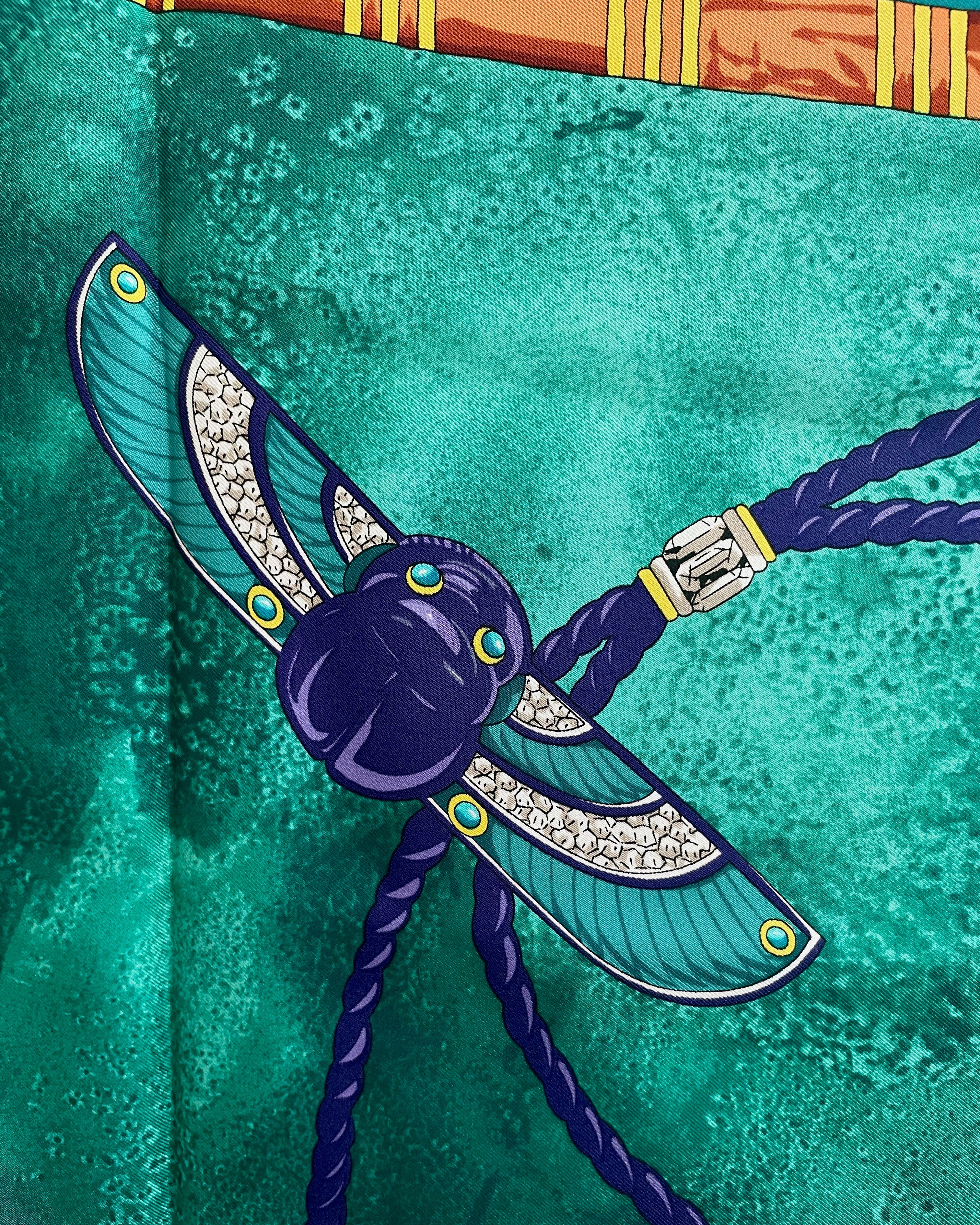 Close-up of Scarab Brooch motif on vintage dark green Must de Cartier Le Scarabée silk scarf – Auric Vintage