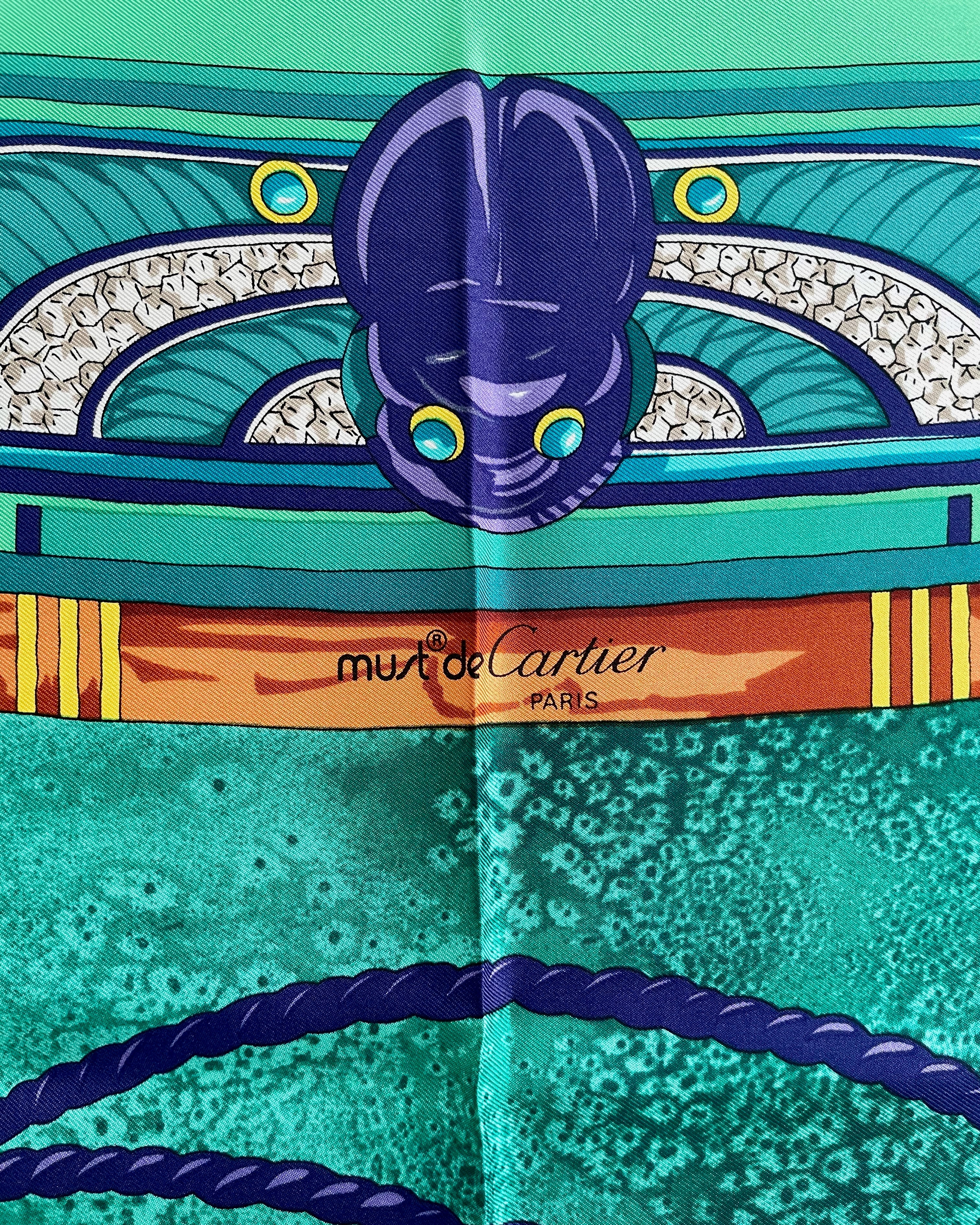 Close-up of Must de Cartier signature on vintage dark green Le Scarabée silk scarf – Auric Vintage
