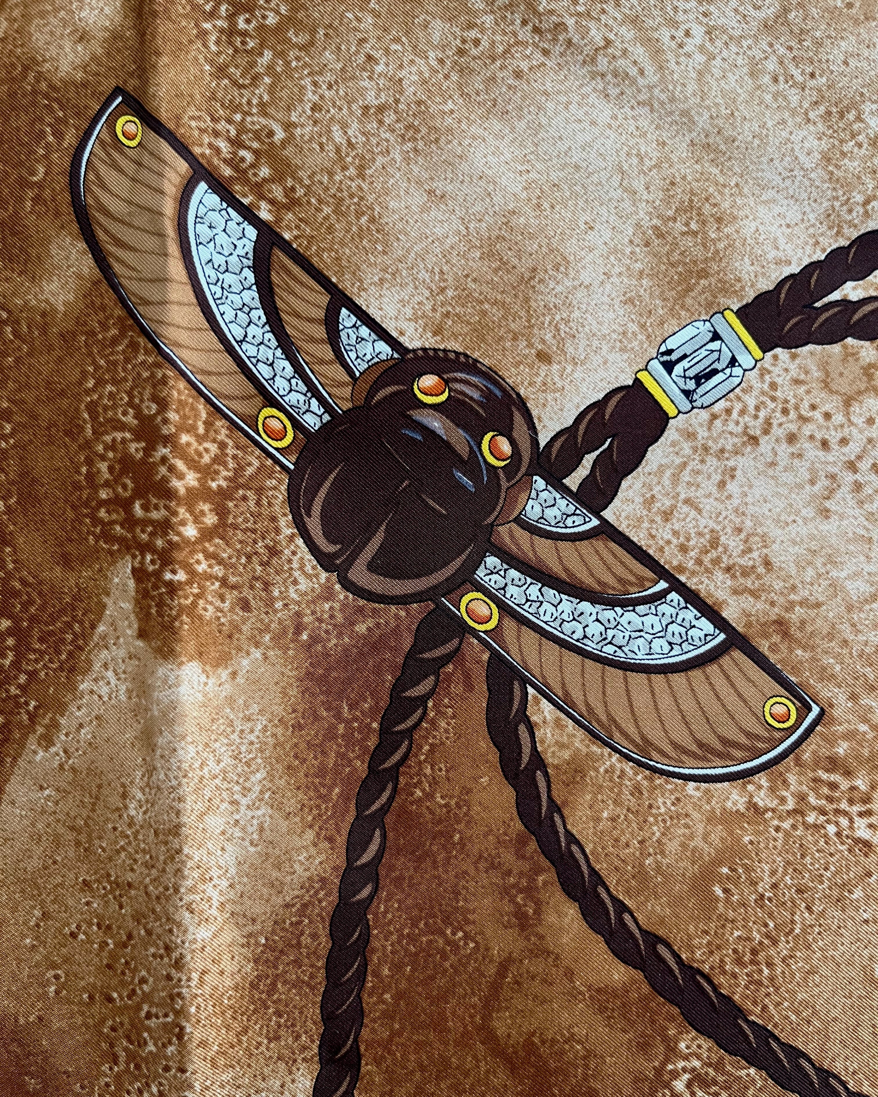 Close-up of Scarab Brooch motif on vintage brown Must de Cartier Le Scarabée silk scarf – Auric Vintage