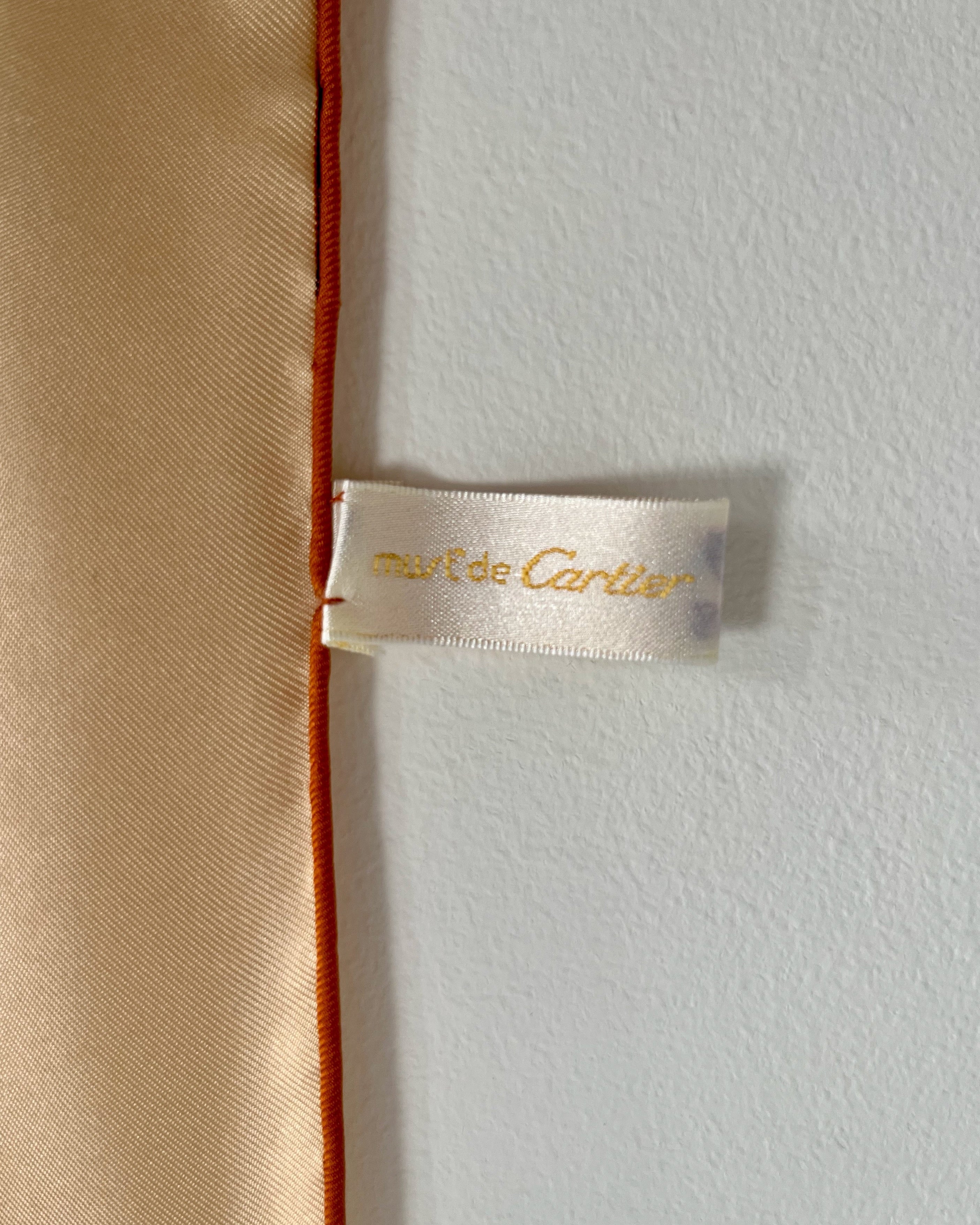 Close-up of original Must de Cartier tag on vintage brown Le Scarabée silk scarf – Auric Vintage