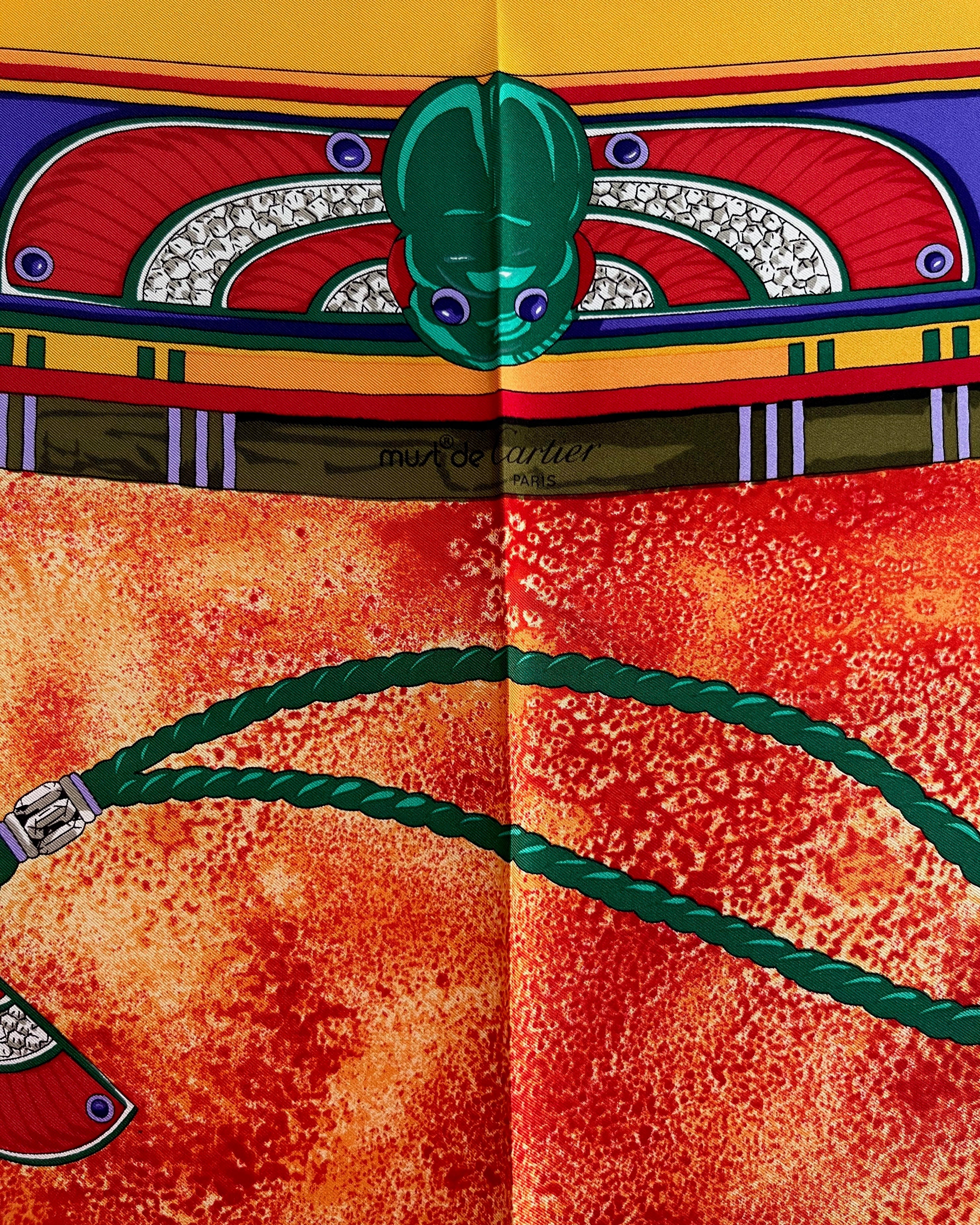 Close-up of Must de Cartier signature on vintage red Le Scarabée silk scarf – Auric Vintage