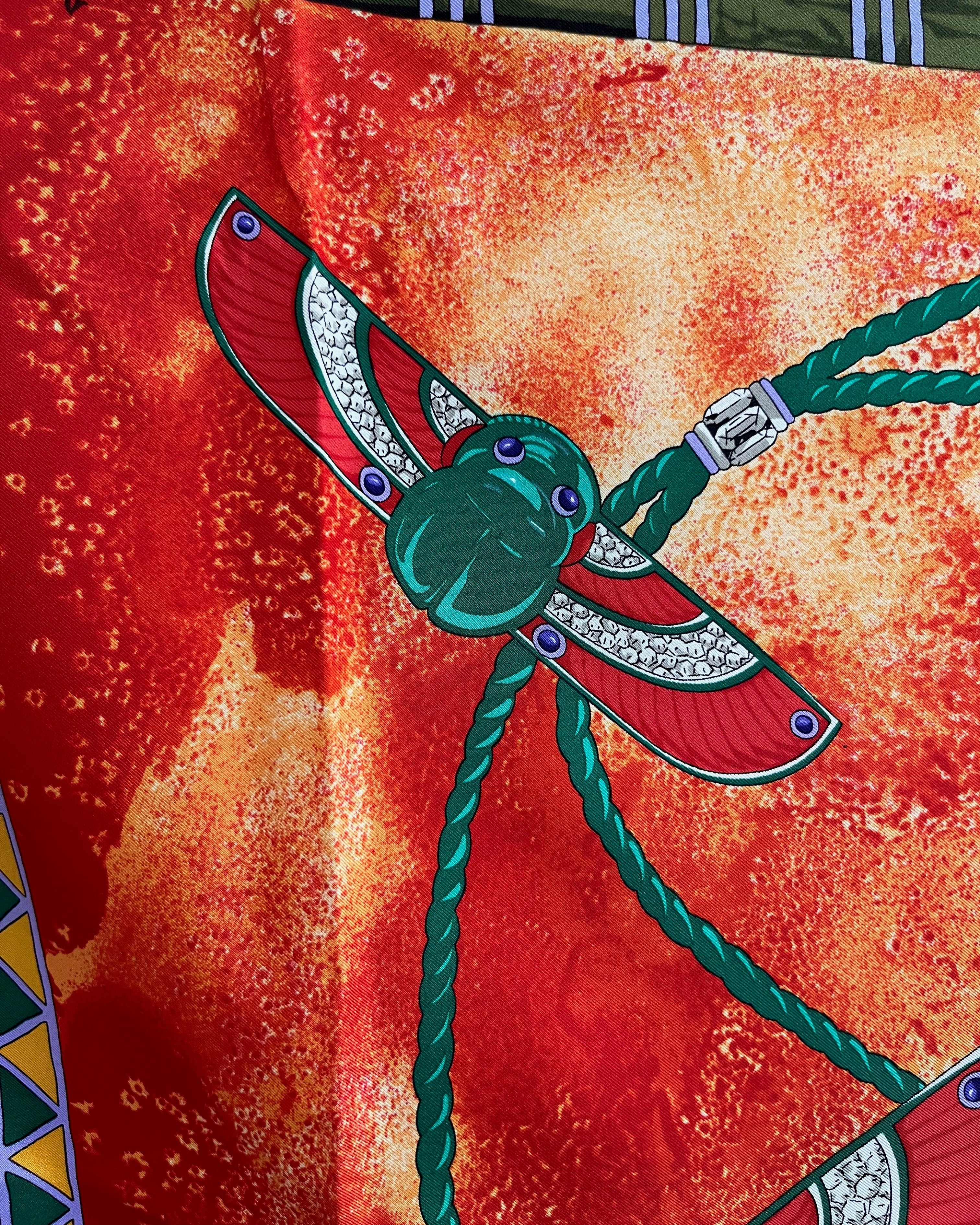 Close-up of Scarab Brooch motif on vintage red Must de Cartier Le Scarabée silk scarf – Auric Vintage