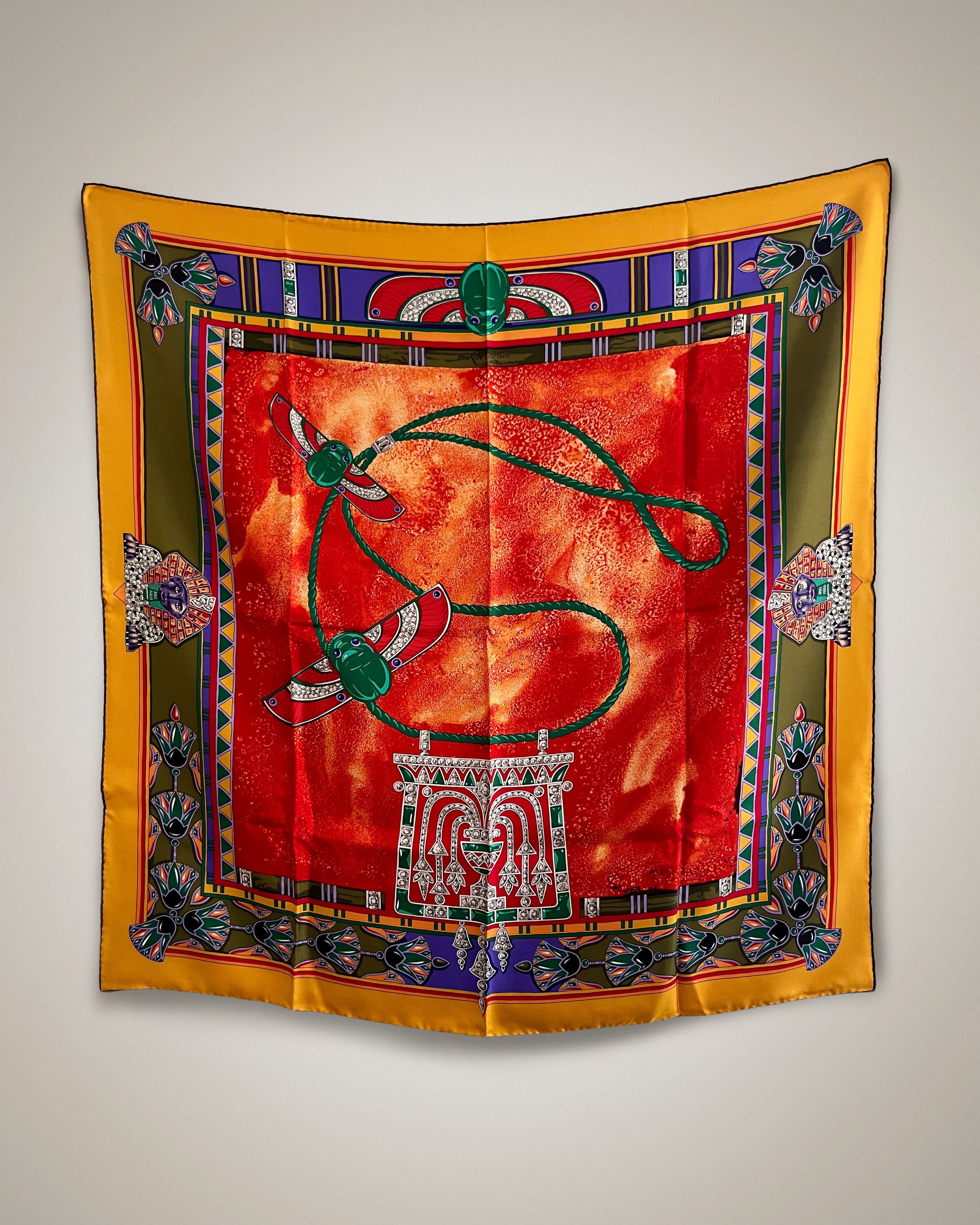 Vintage Must de Cartier Le Scarabée silk scarf in red featuring Egyptomania-inspired design, hanging display – Auric Vintage